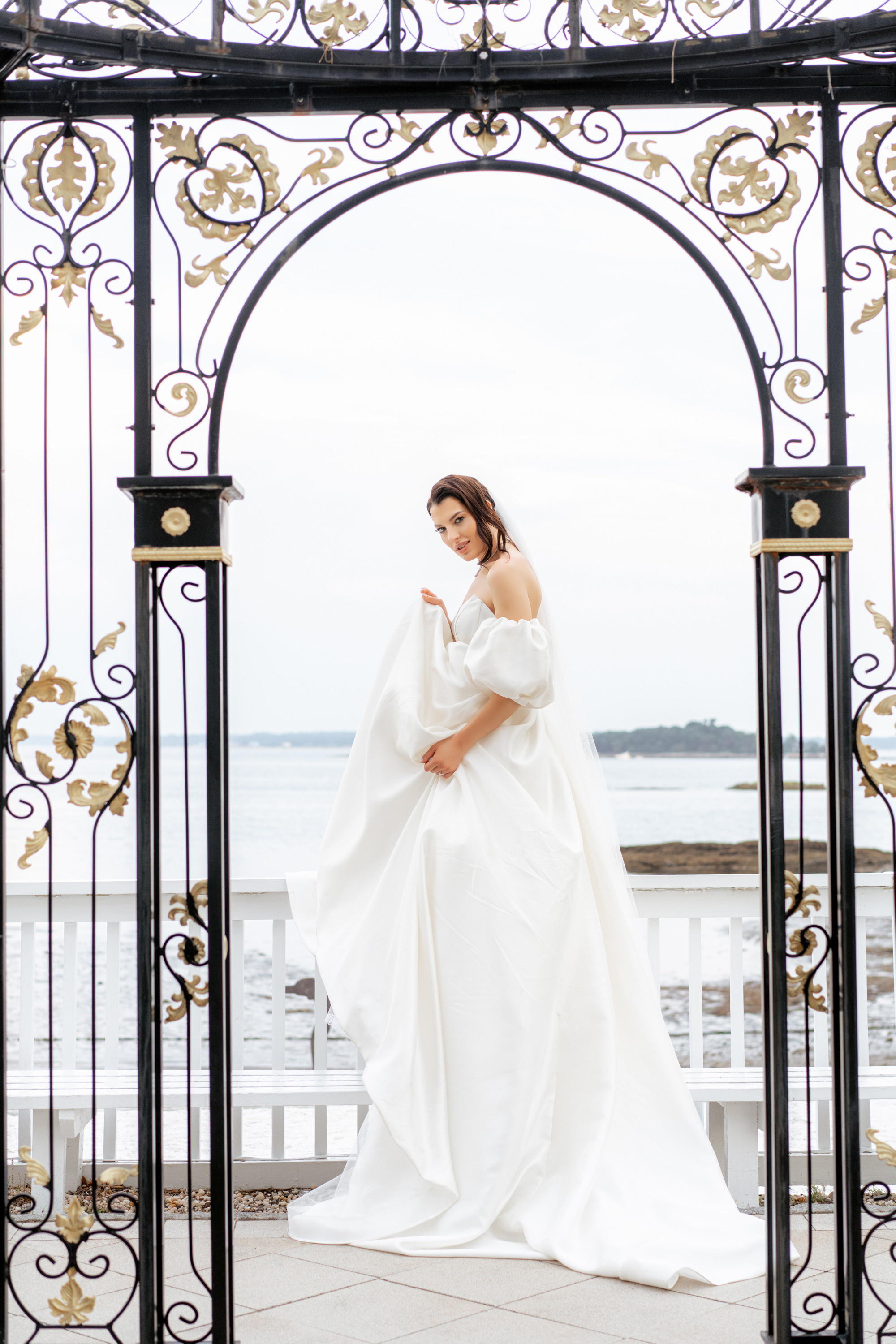 a woman in a white dress standing in front of a gate