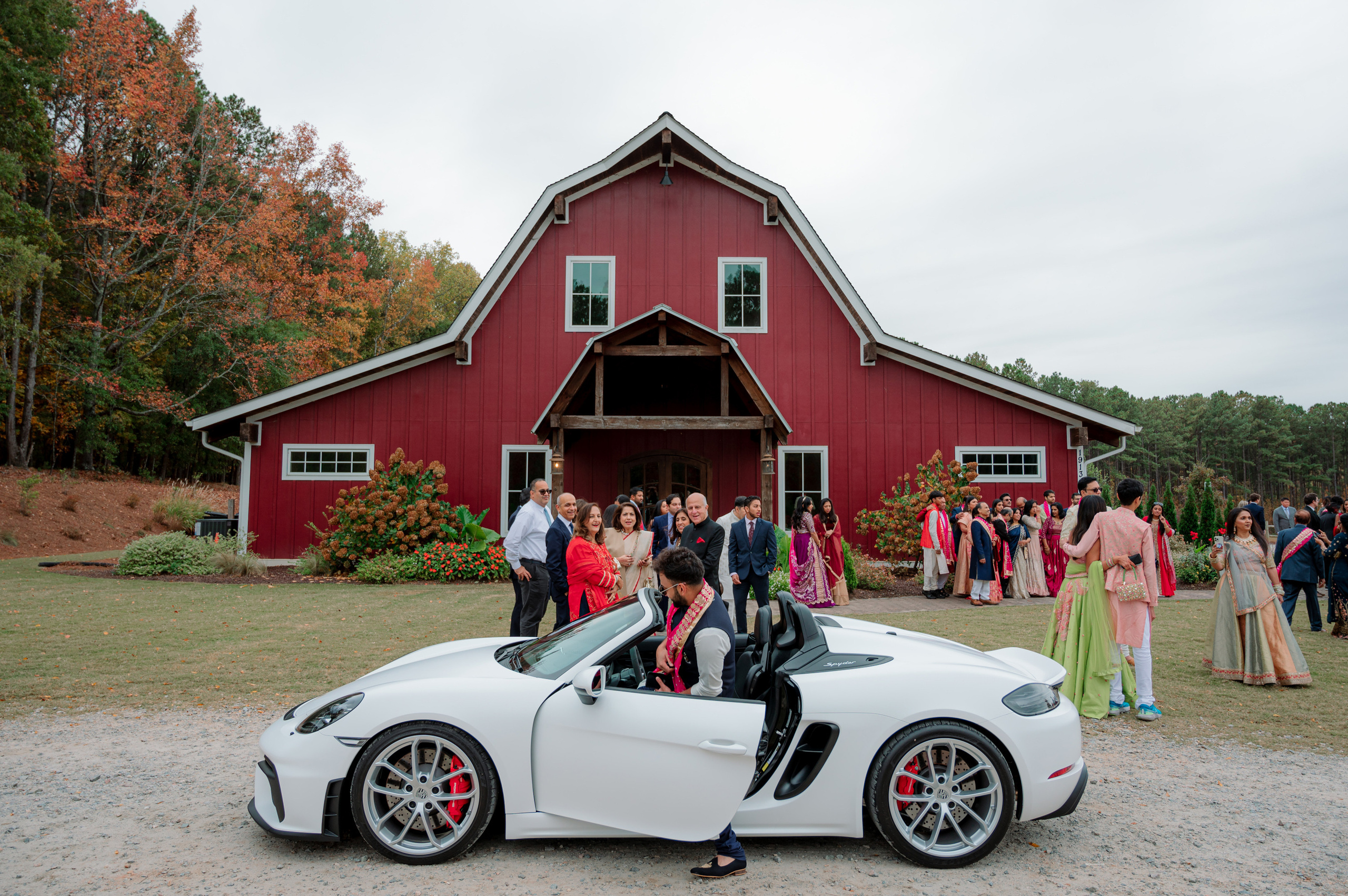 a group of people standing around a white sports car