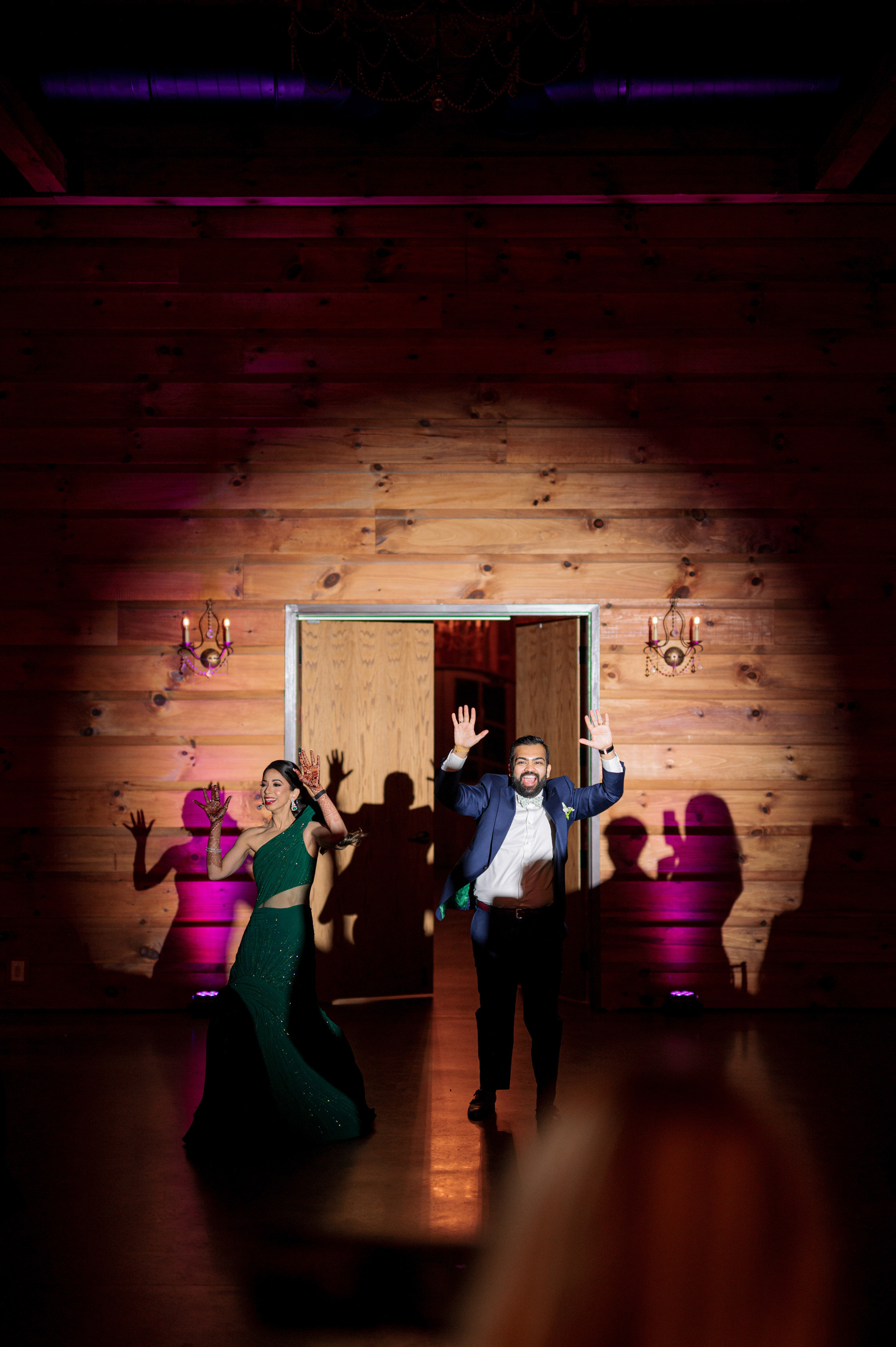 a couple dancing in a room with a light on the wall