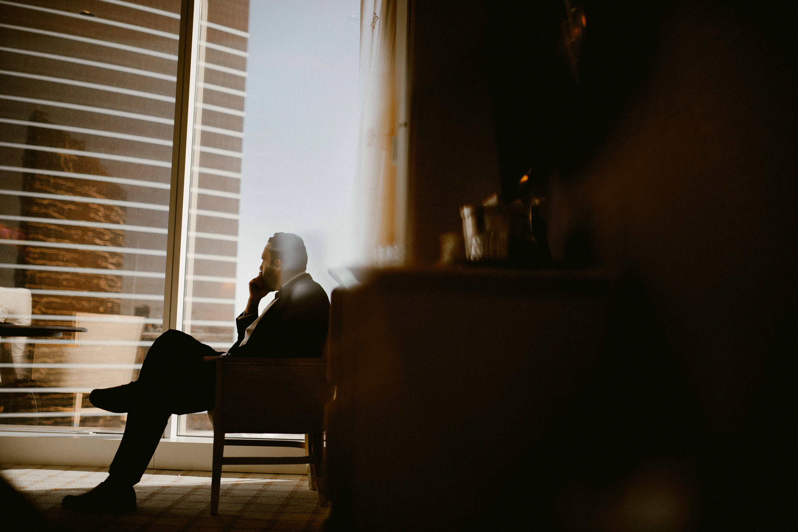 a man sitting in a chair looking out a window