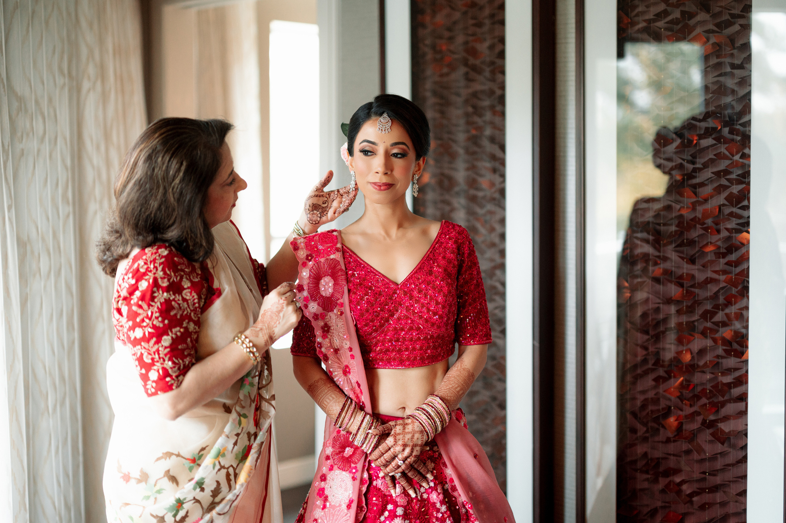a woman in a pink dress is putting her makeup