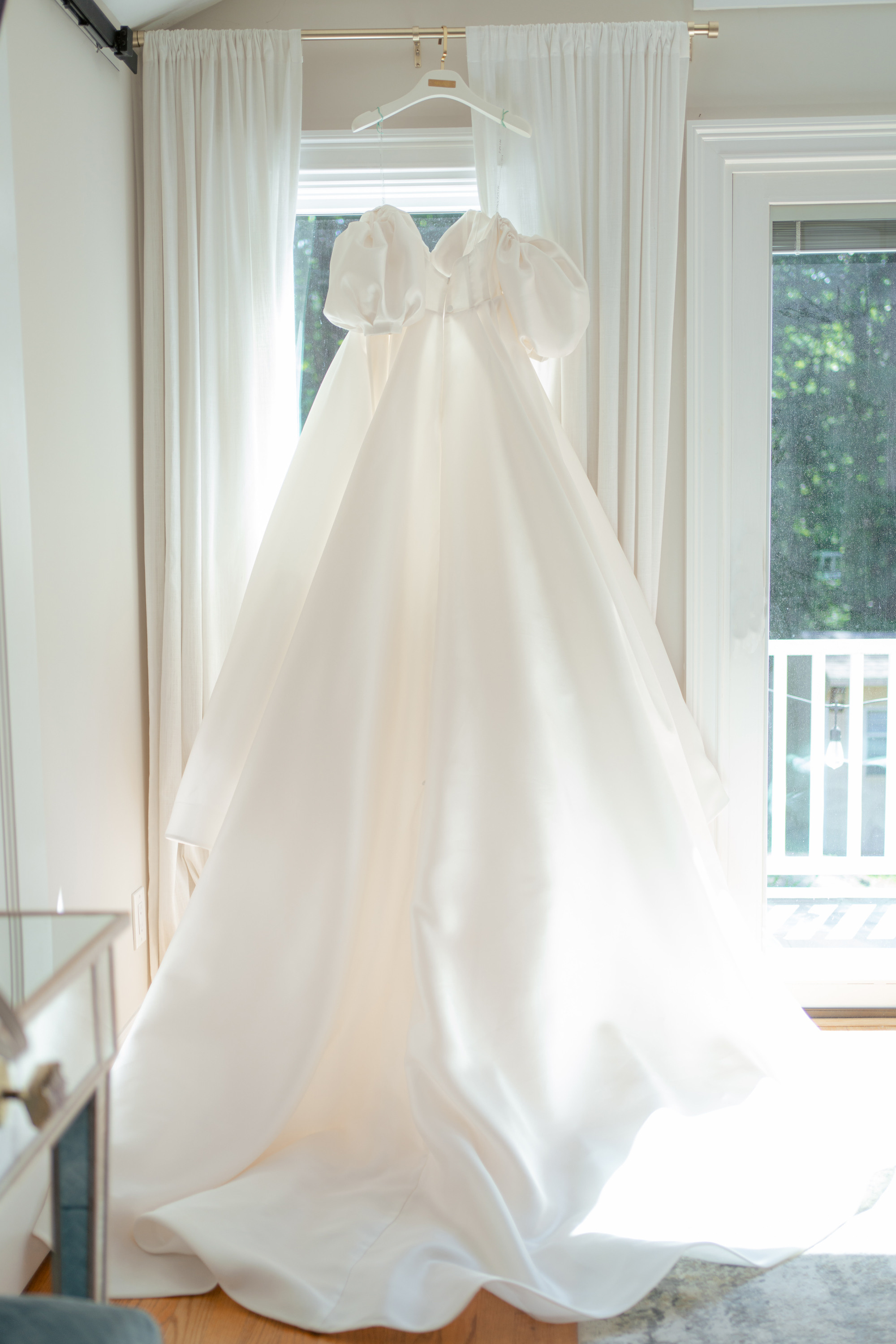 a wedding dress hanging on a hanger