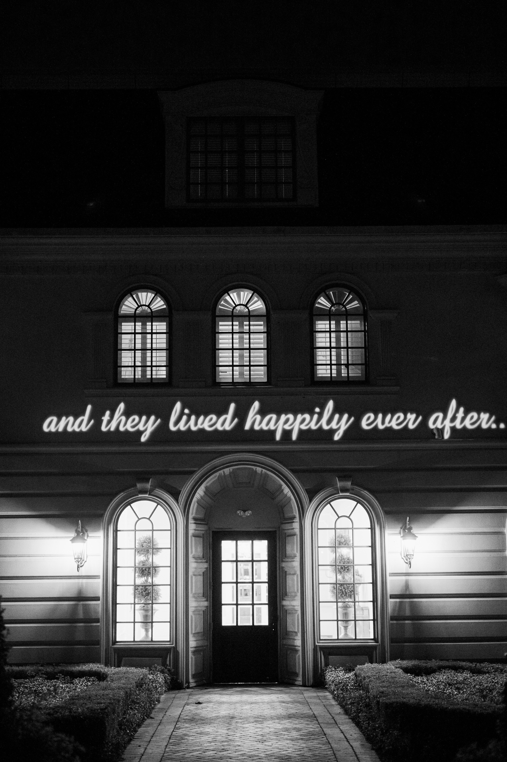 an old building with a neon sign that says, and we have happily ever