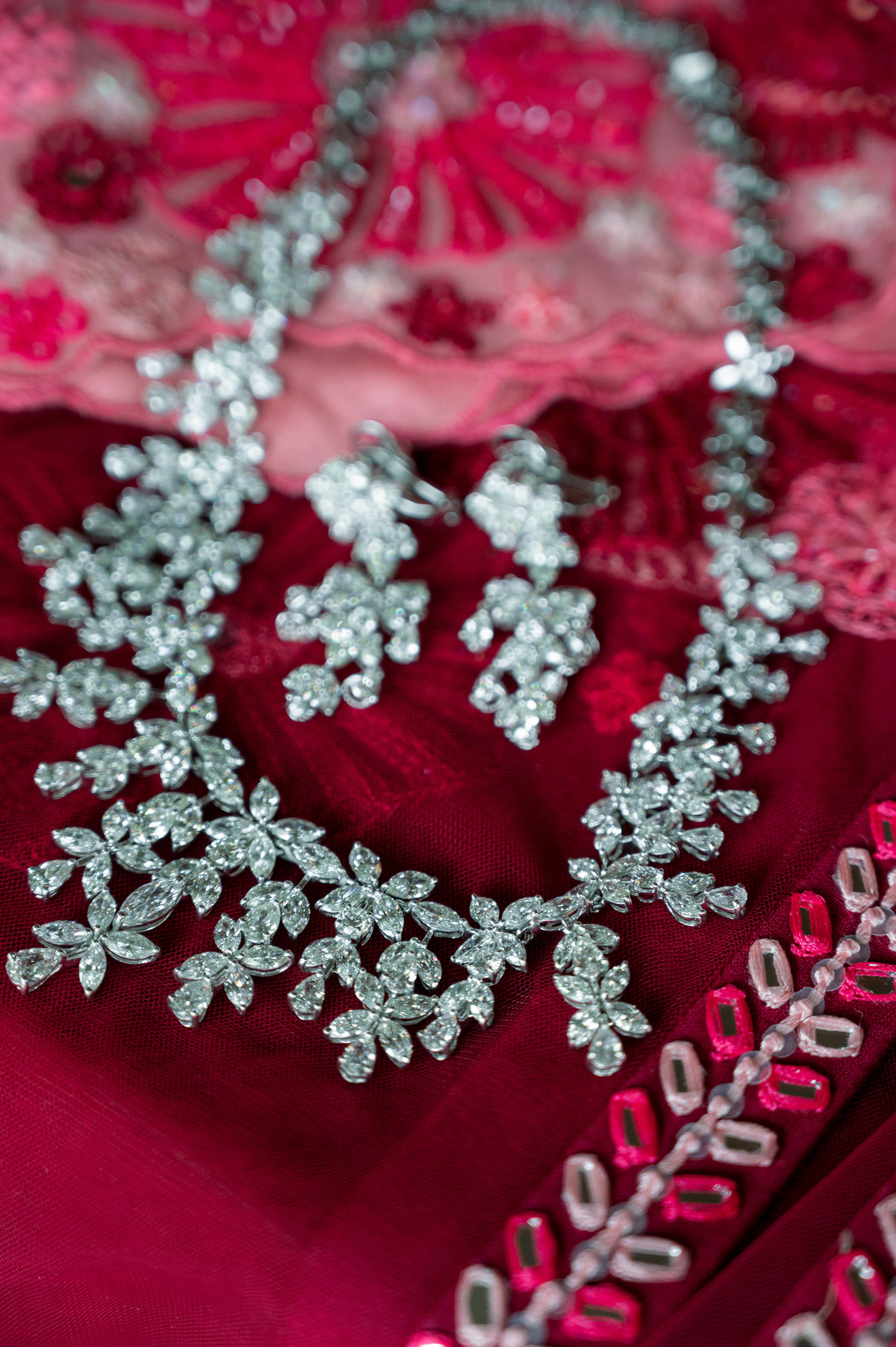 a close up of a red dress with silver and silver flowers