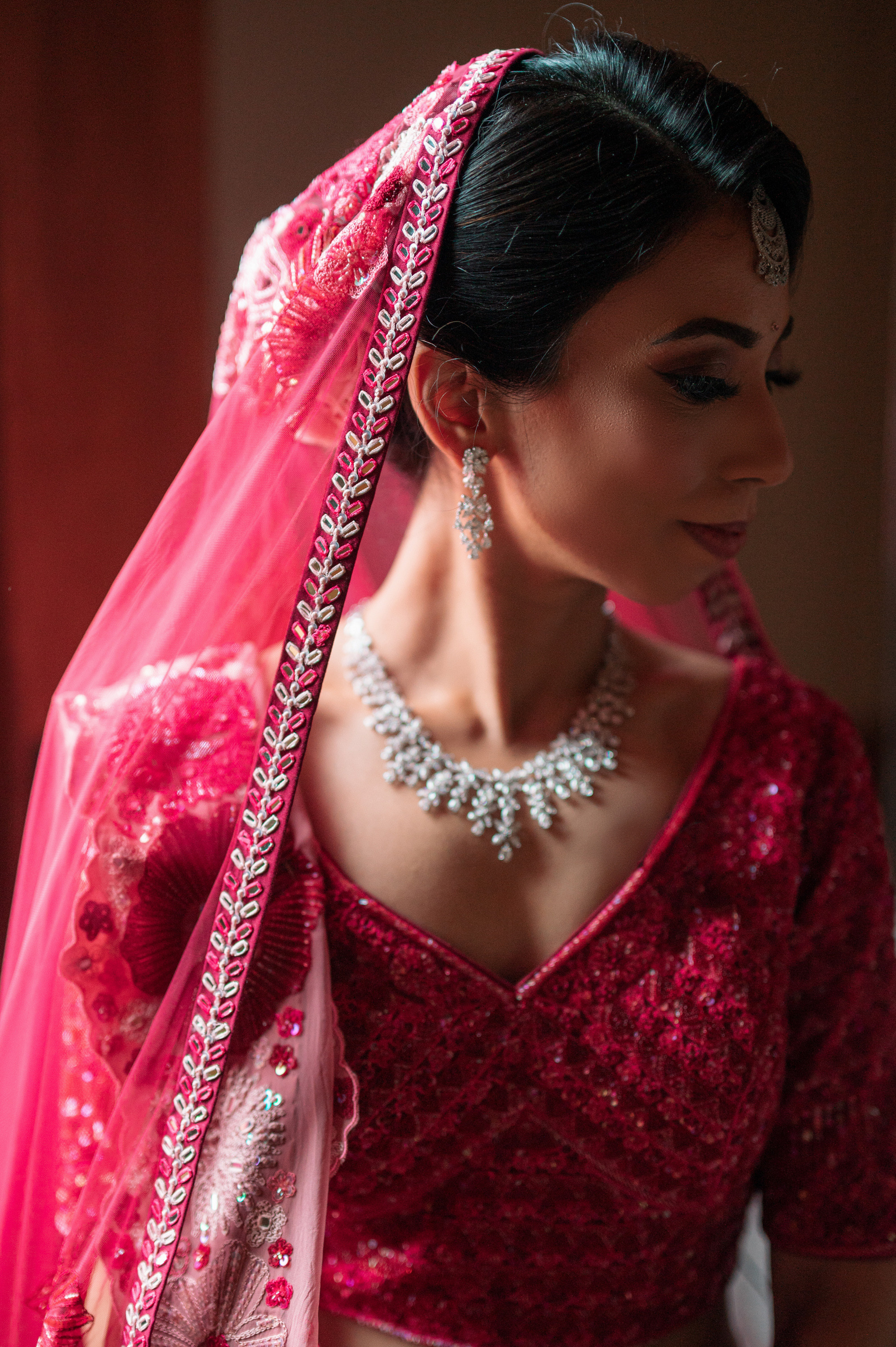 a woman in a red dress and a pink veil