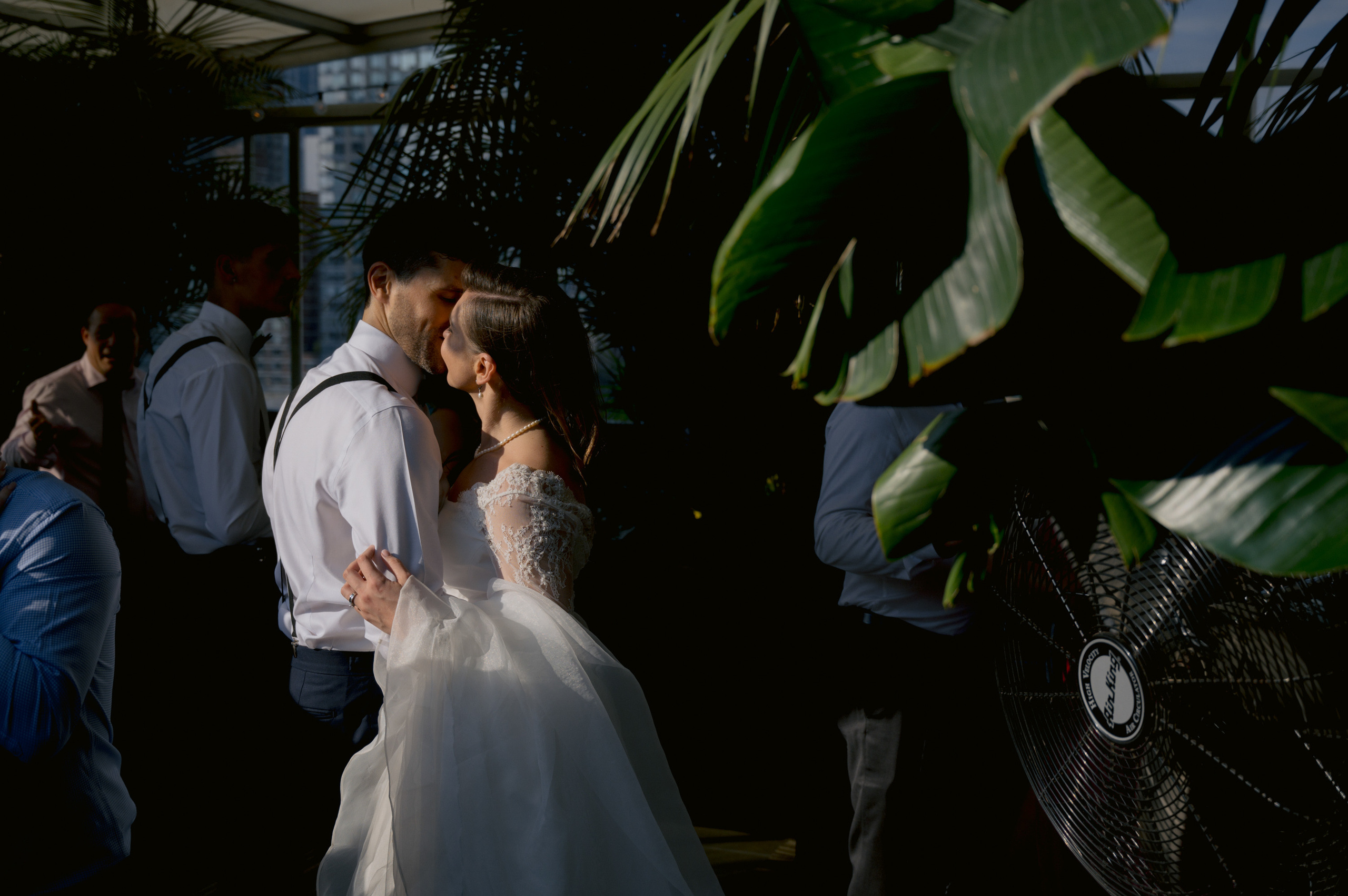 a bride and groom kissing in a greenhouse