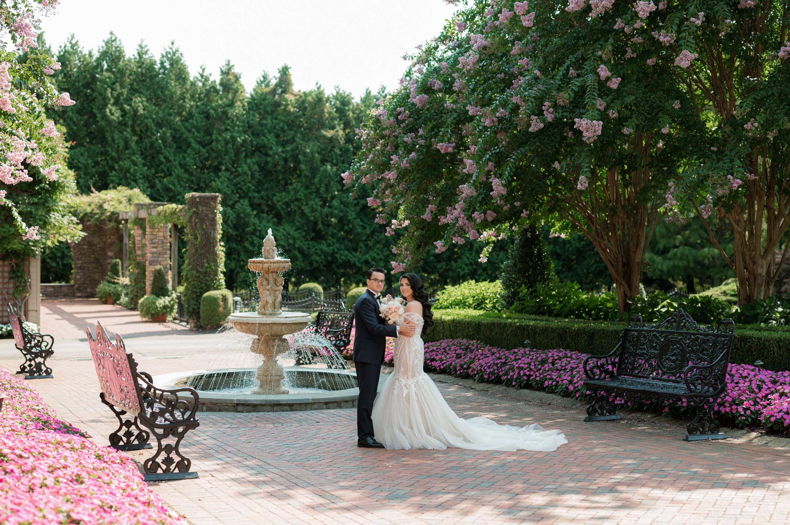 a bride and groom standing in a garden