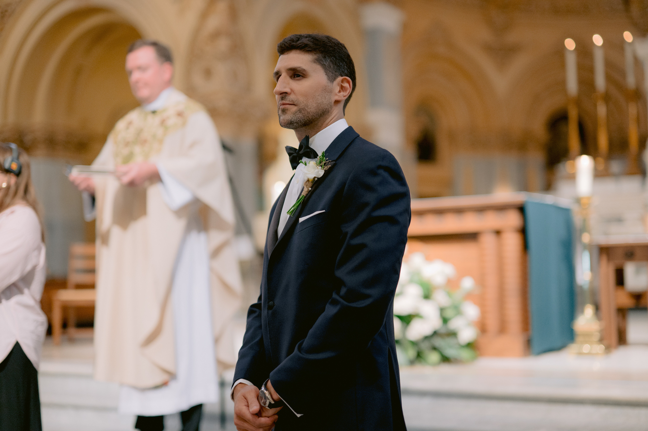 a man in a suit and tie standing in front of a priest
