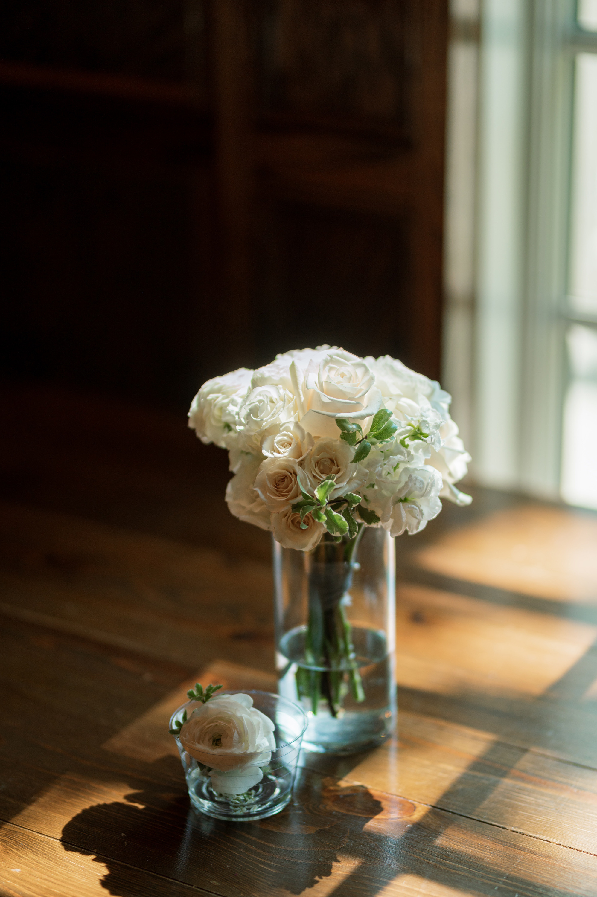 a vase of white flowers on a wooden table
