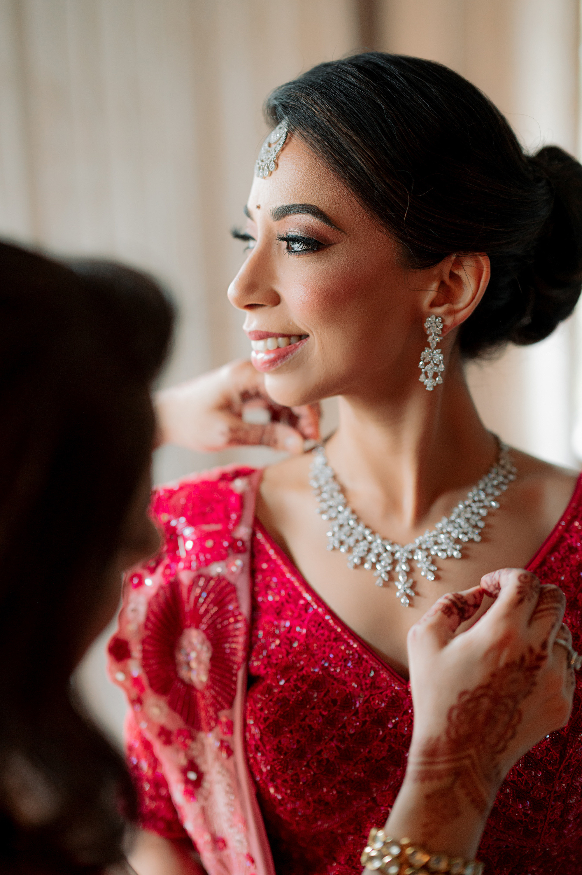 a woman in a red dress is putting her jewelry