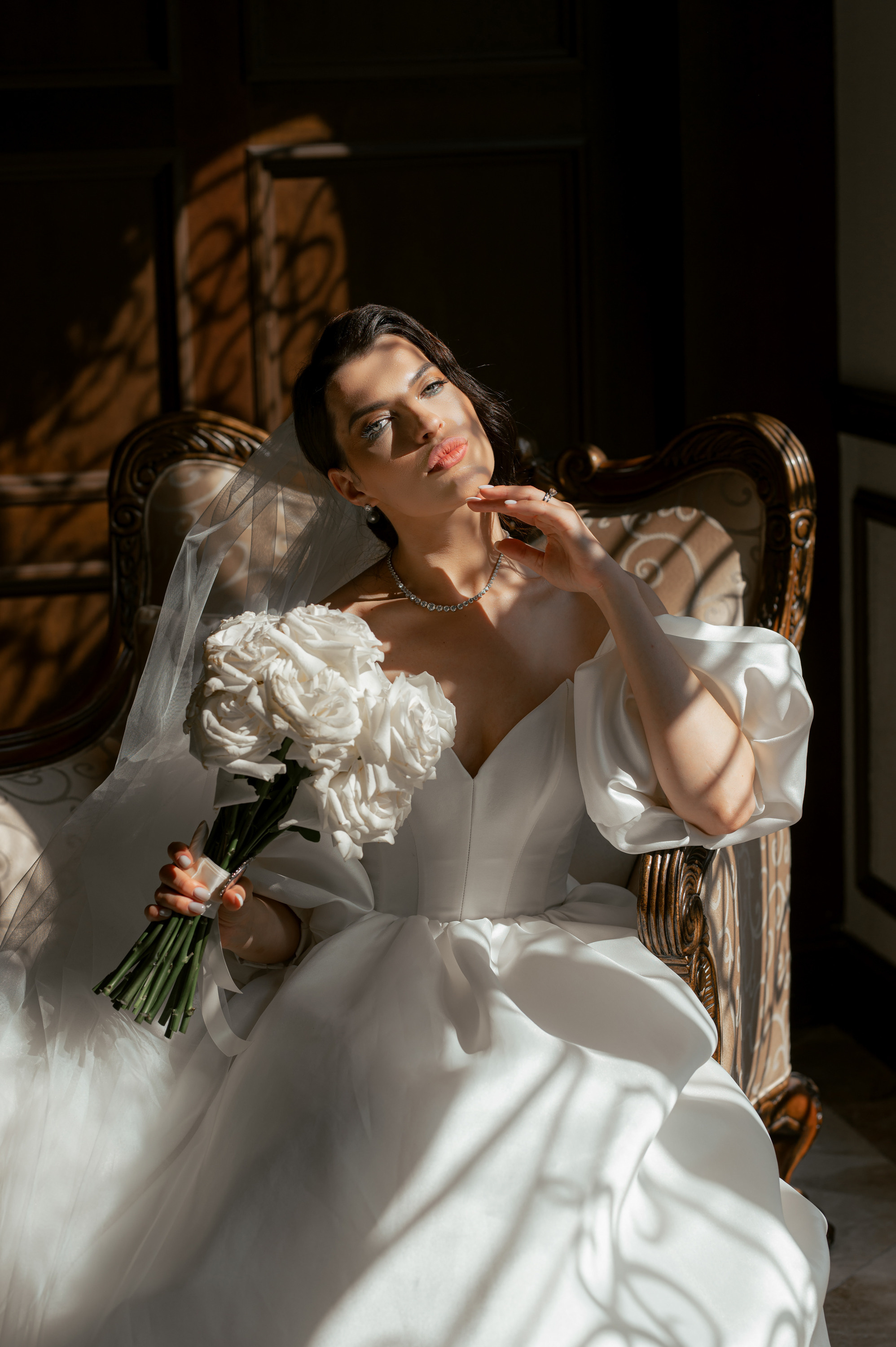 a woman in a white dress sitting on a chair
