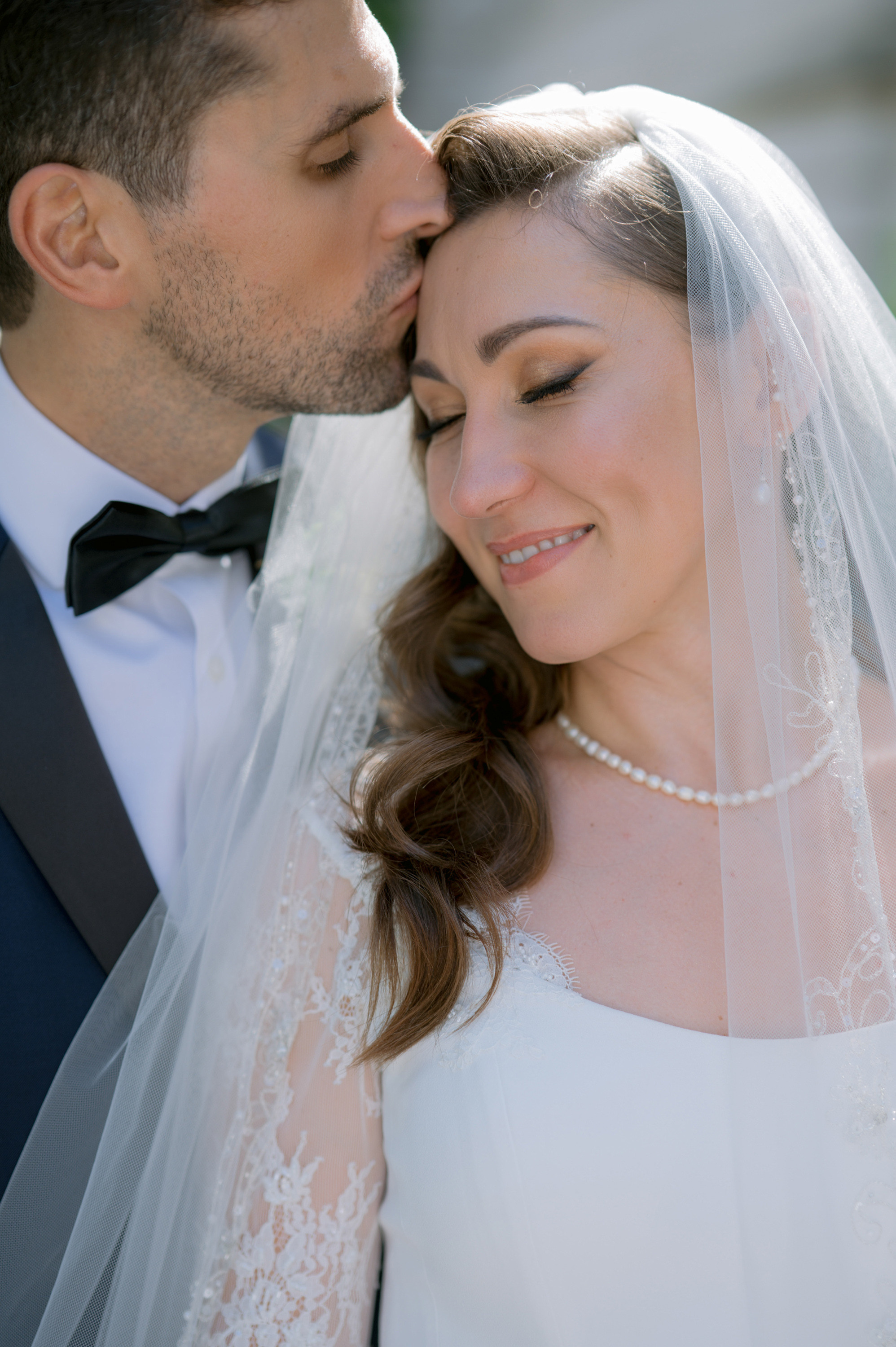 a bride and groom kissing in front of a building