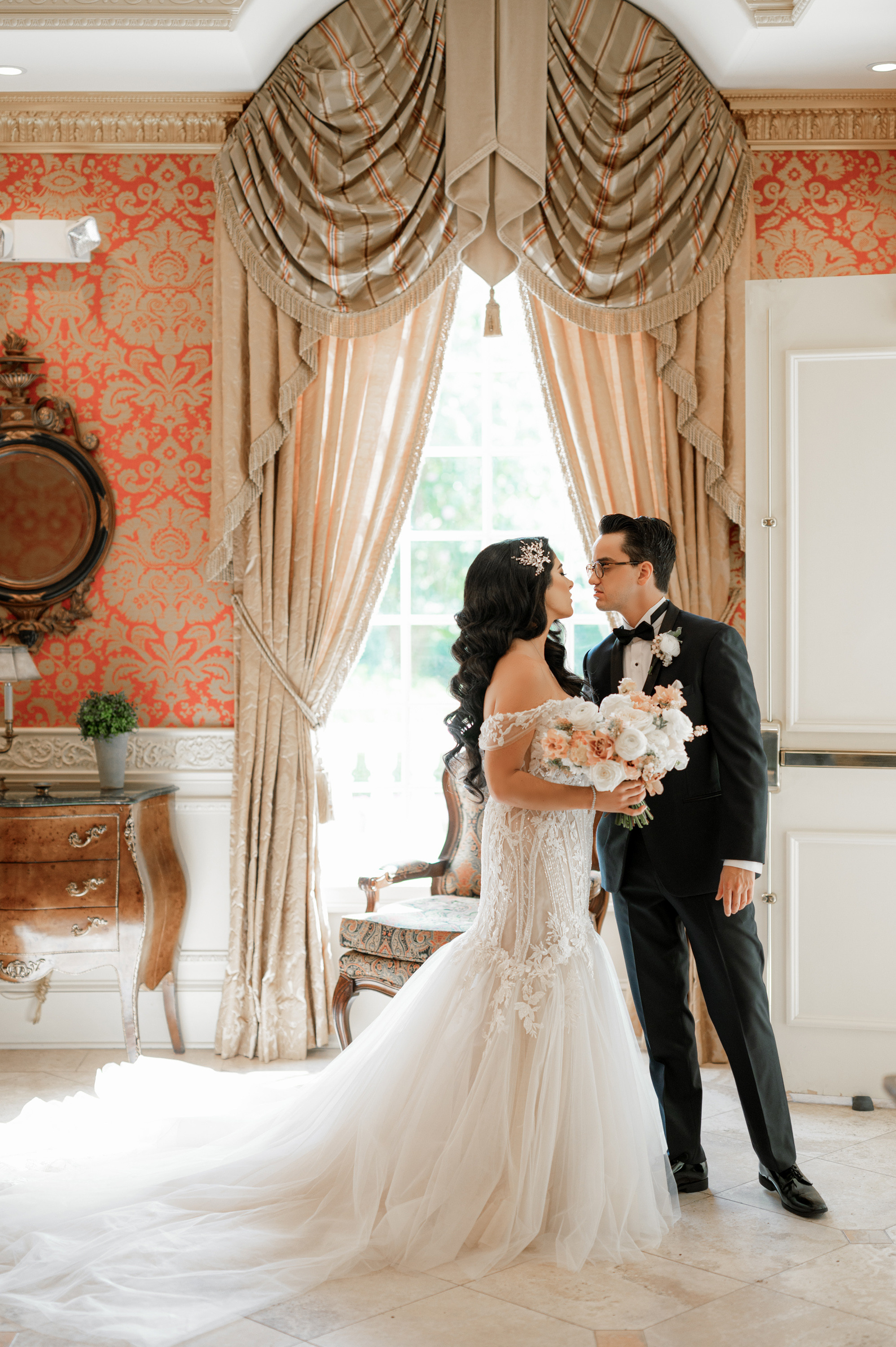a bride and groom kissing in a room