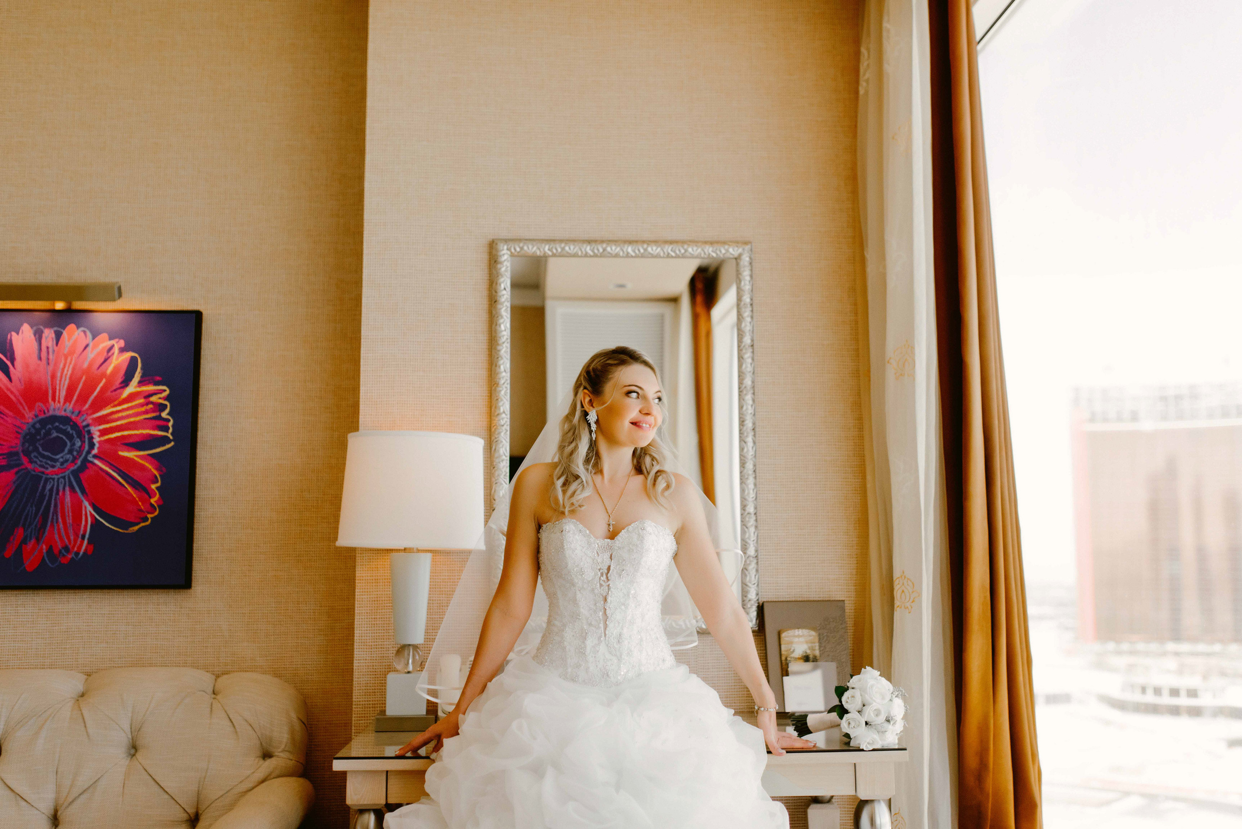 a bride in a wedding dress is sitting on a chair