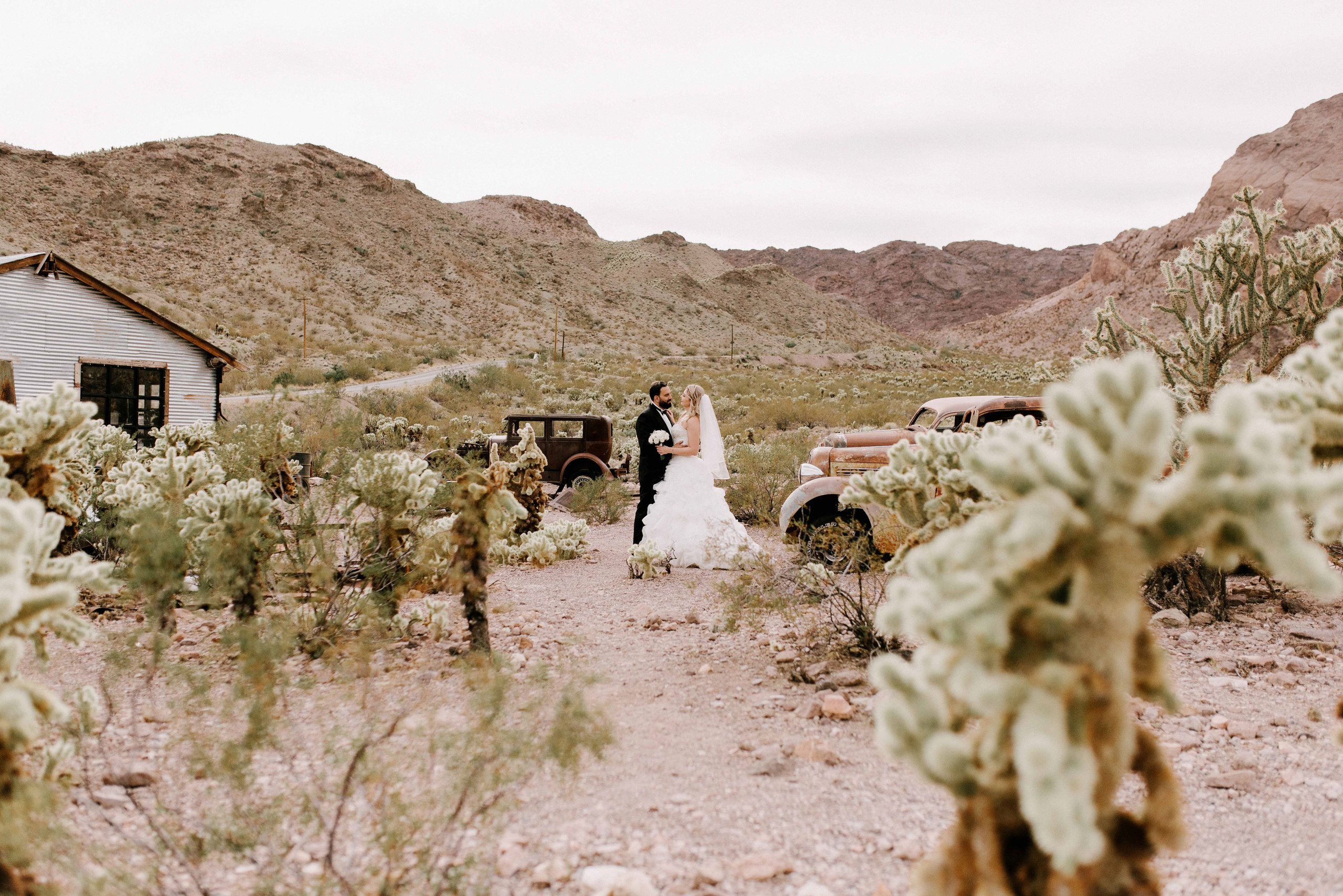a couple standing in front of a house in the desert