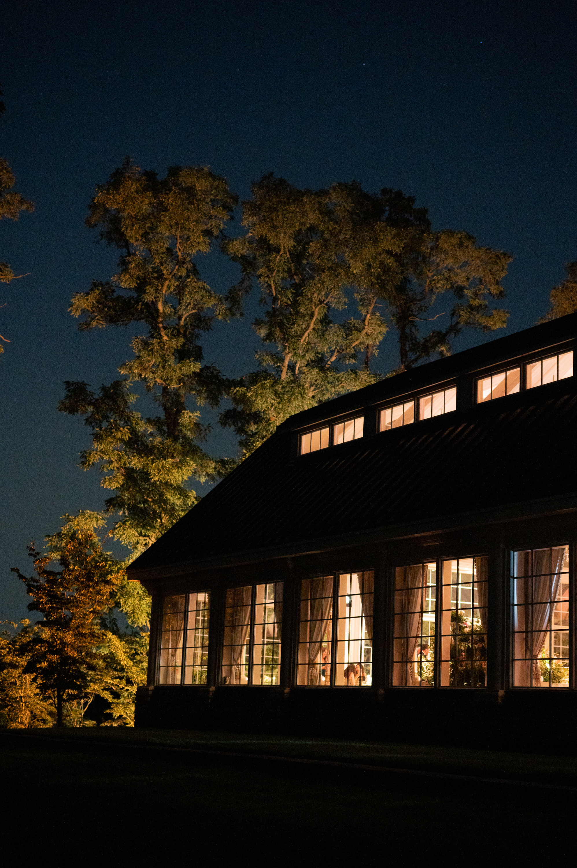 a house lit up at night with a tree in the background