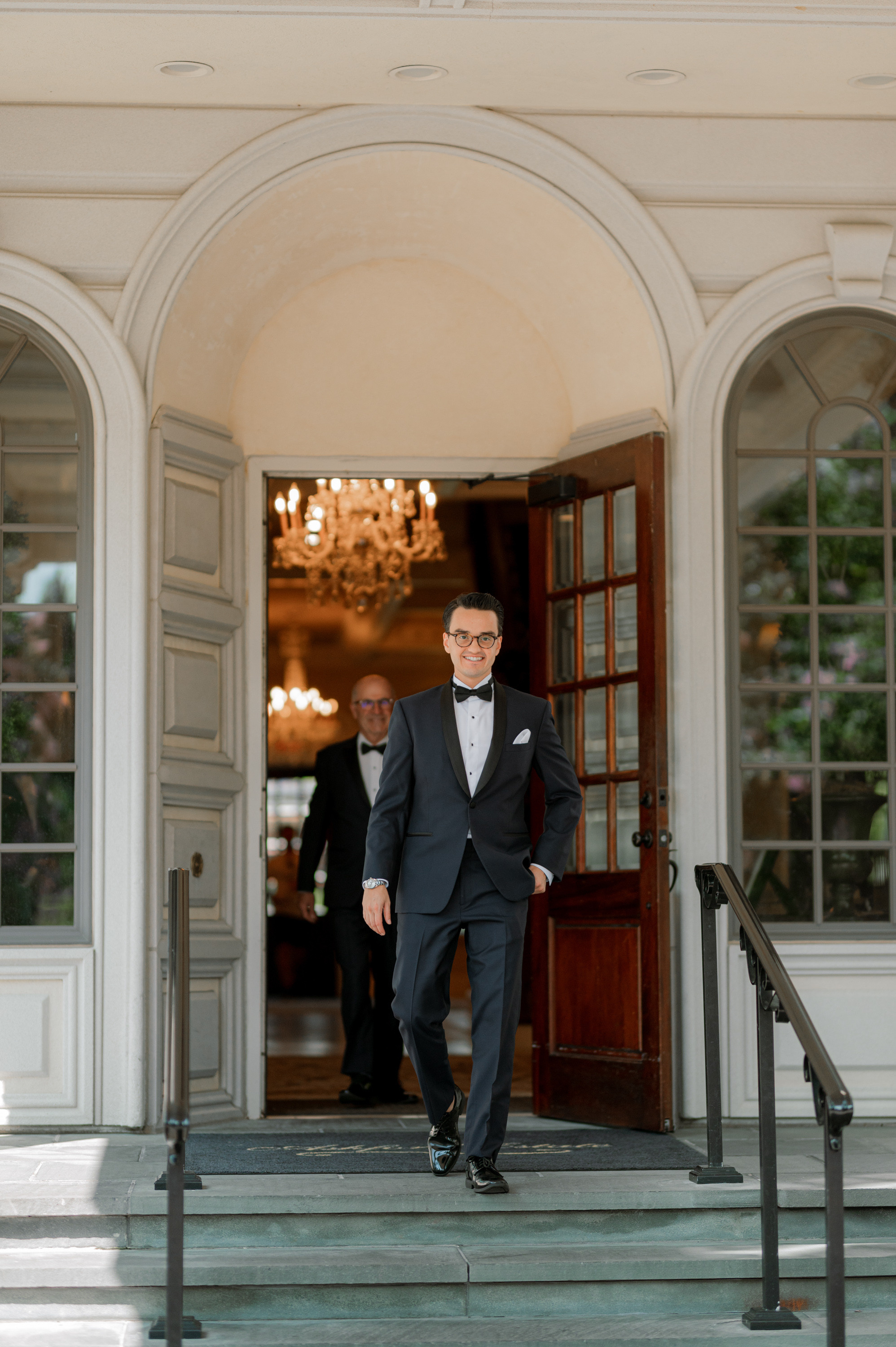 a man in a tuxed suit is entering a house