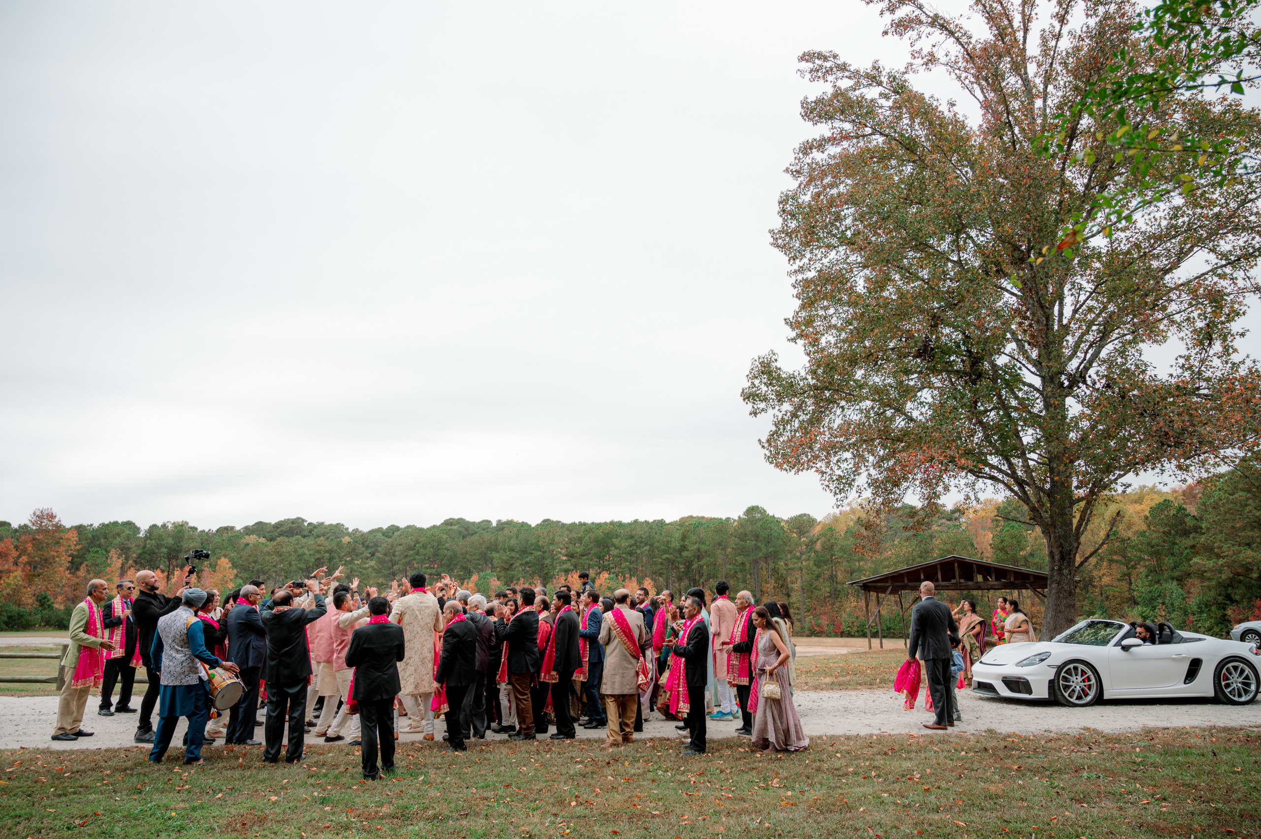 a group of people standing around a white car