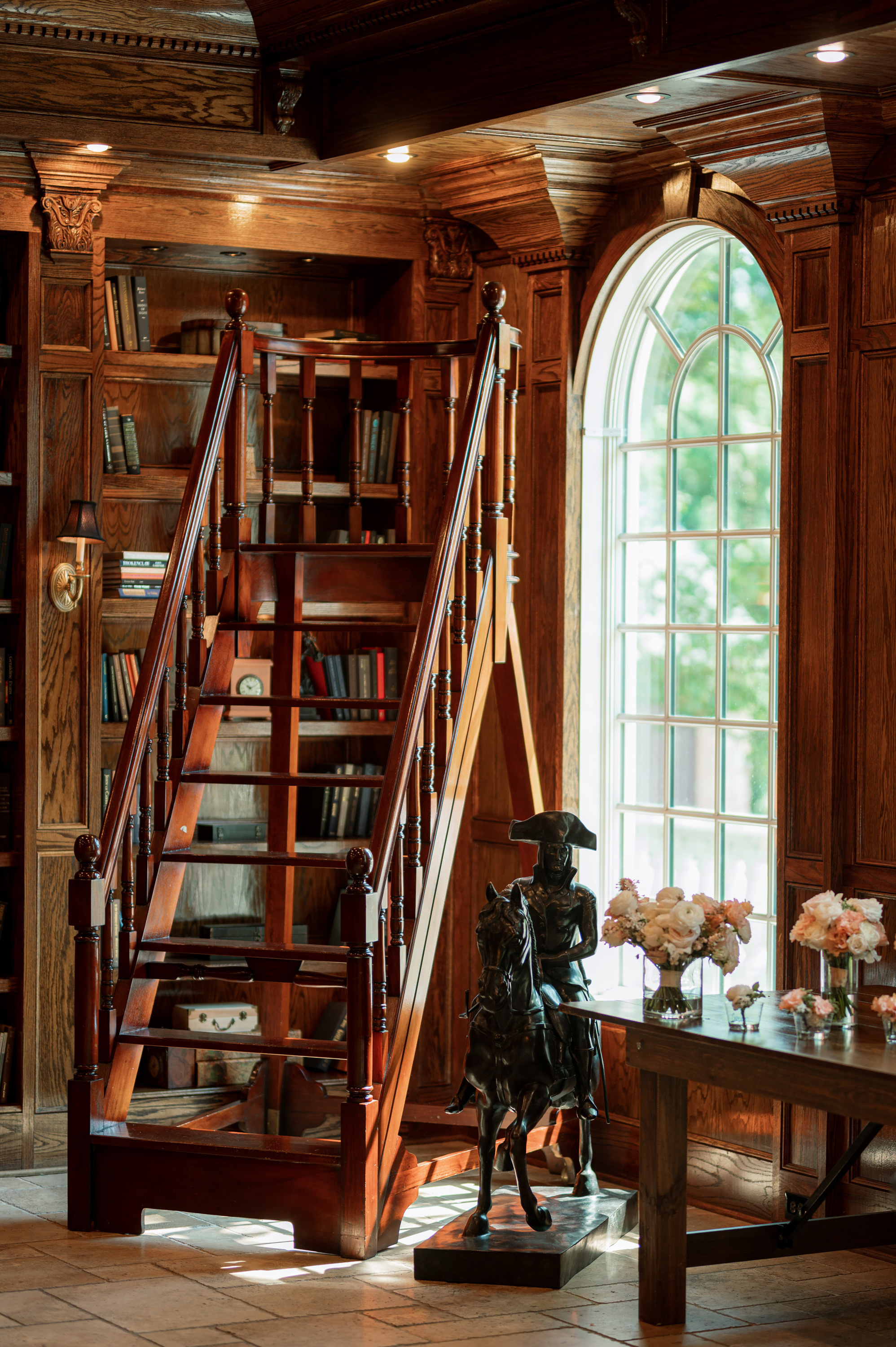 a living room with a staircase and a statue