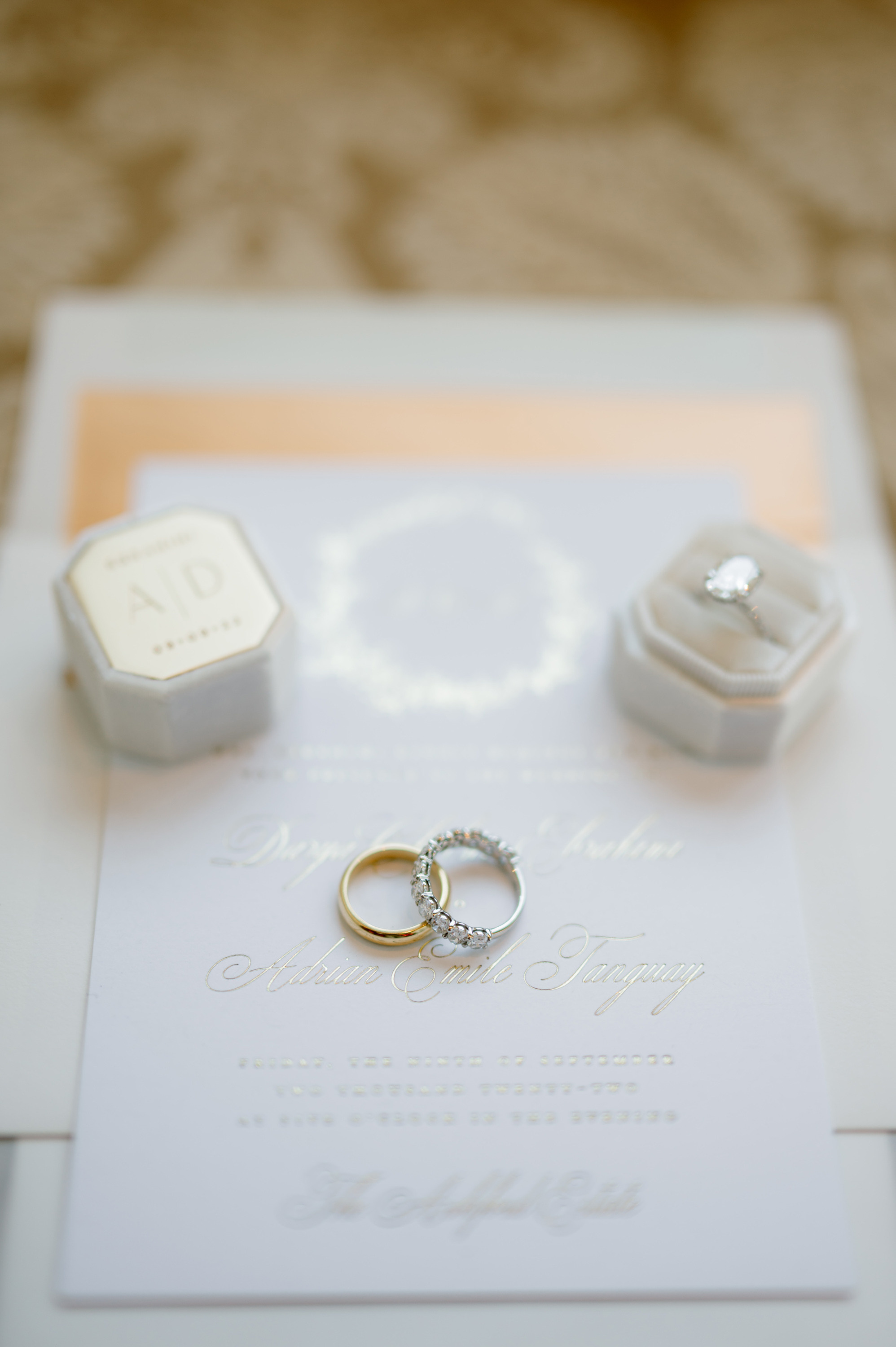 a wedding ring sits on a white invitation