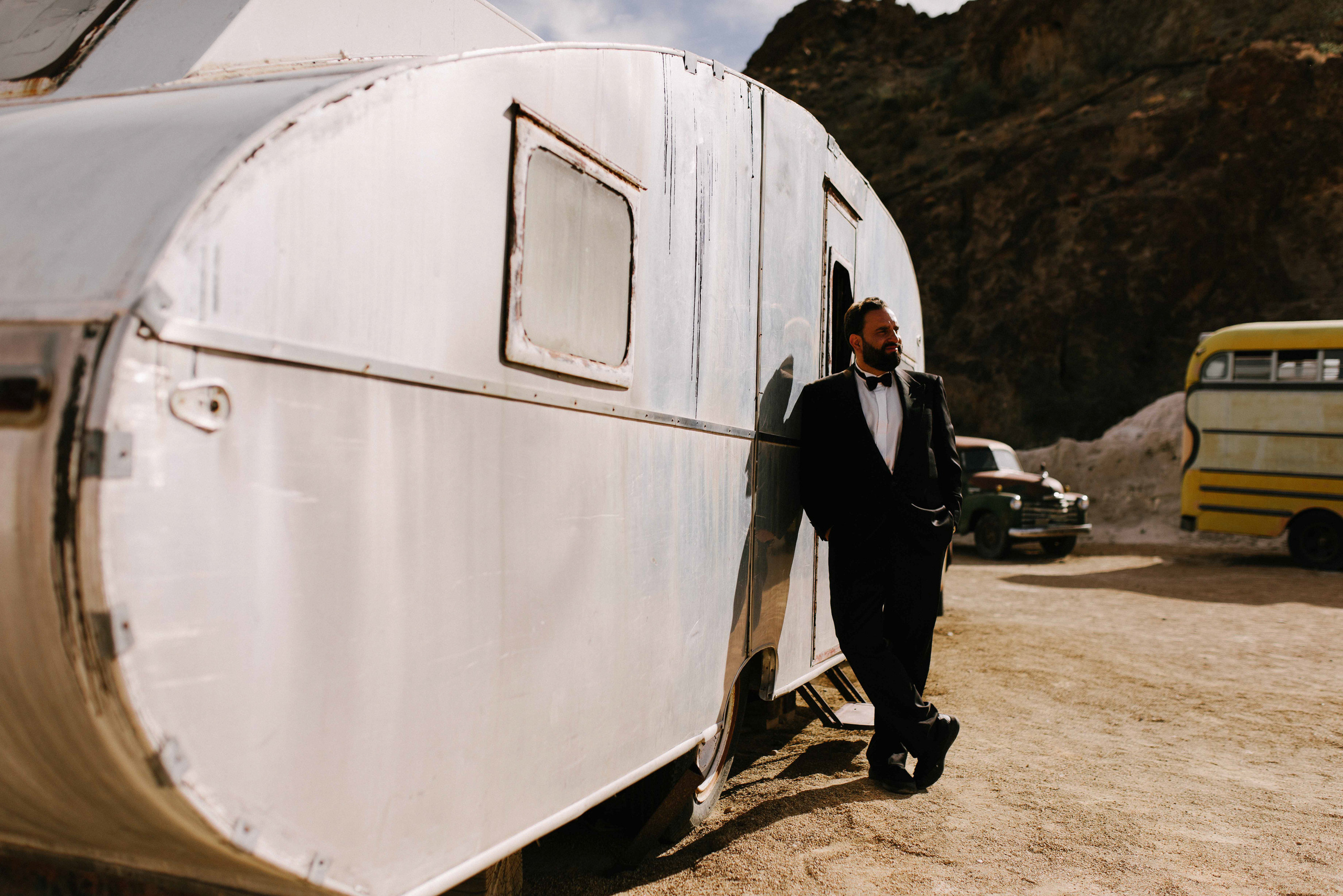 a man in a suit standing next to a trailer