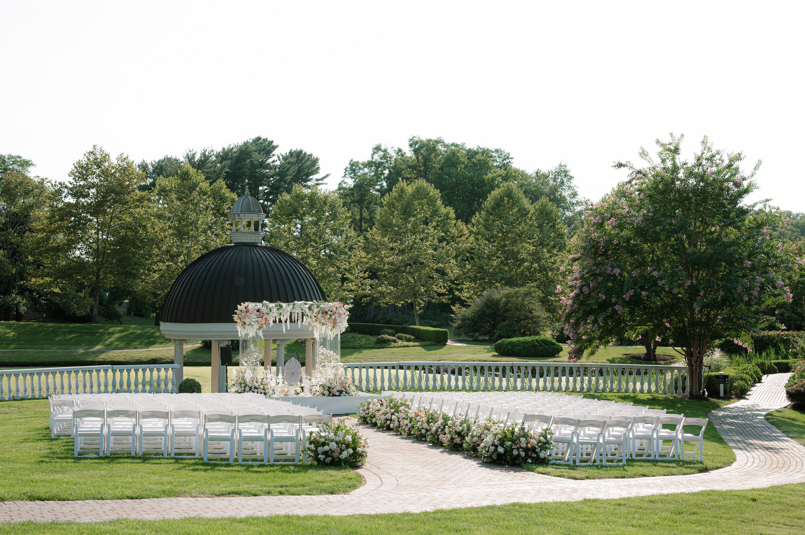 a wedding ceremony setup with white chairs and a gaze