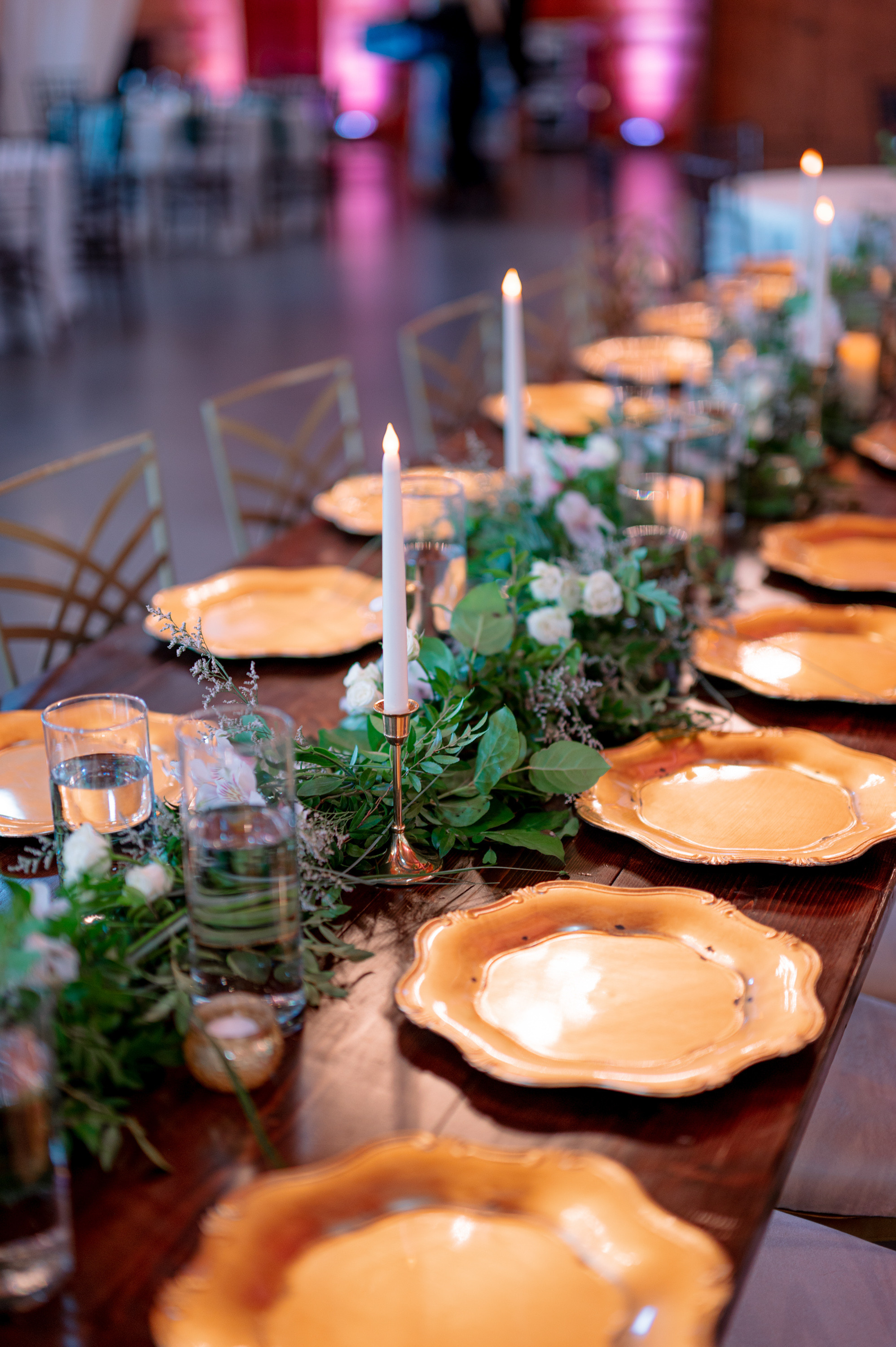a long table with plates and candles on it