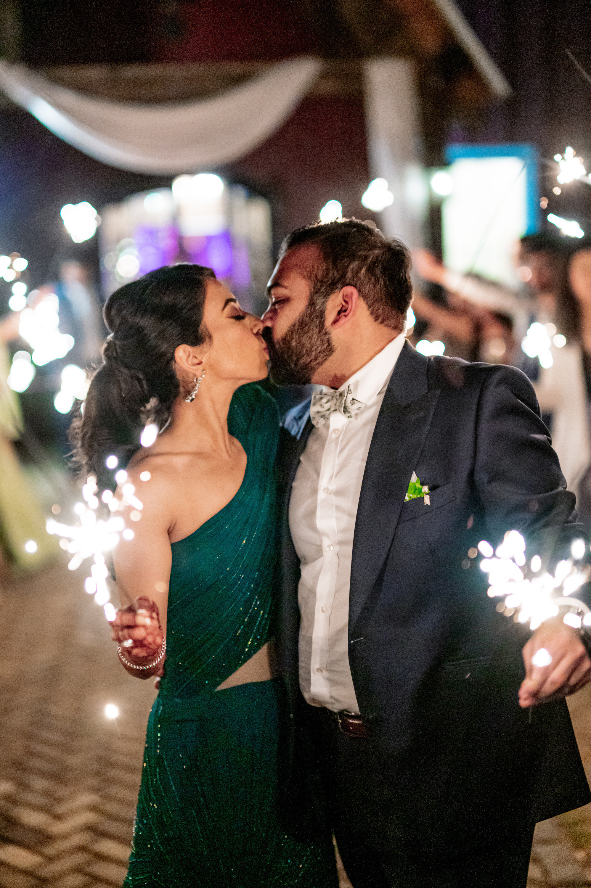 a couple kissing while holding sparkle sticks