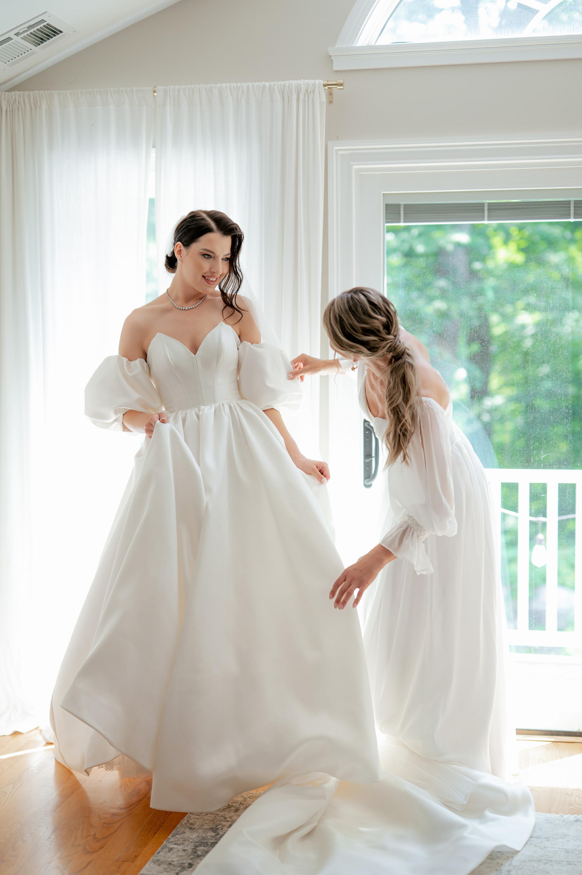 a bride and her bridesmaid in a white dress