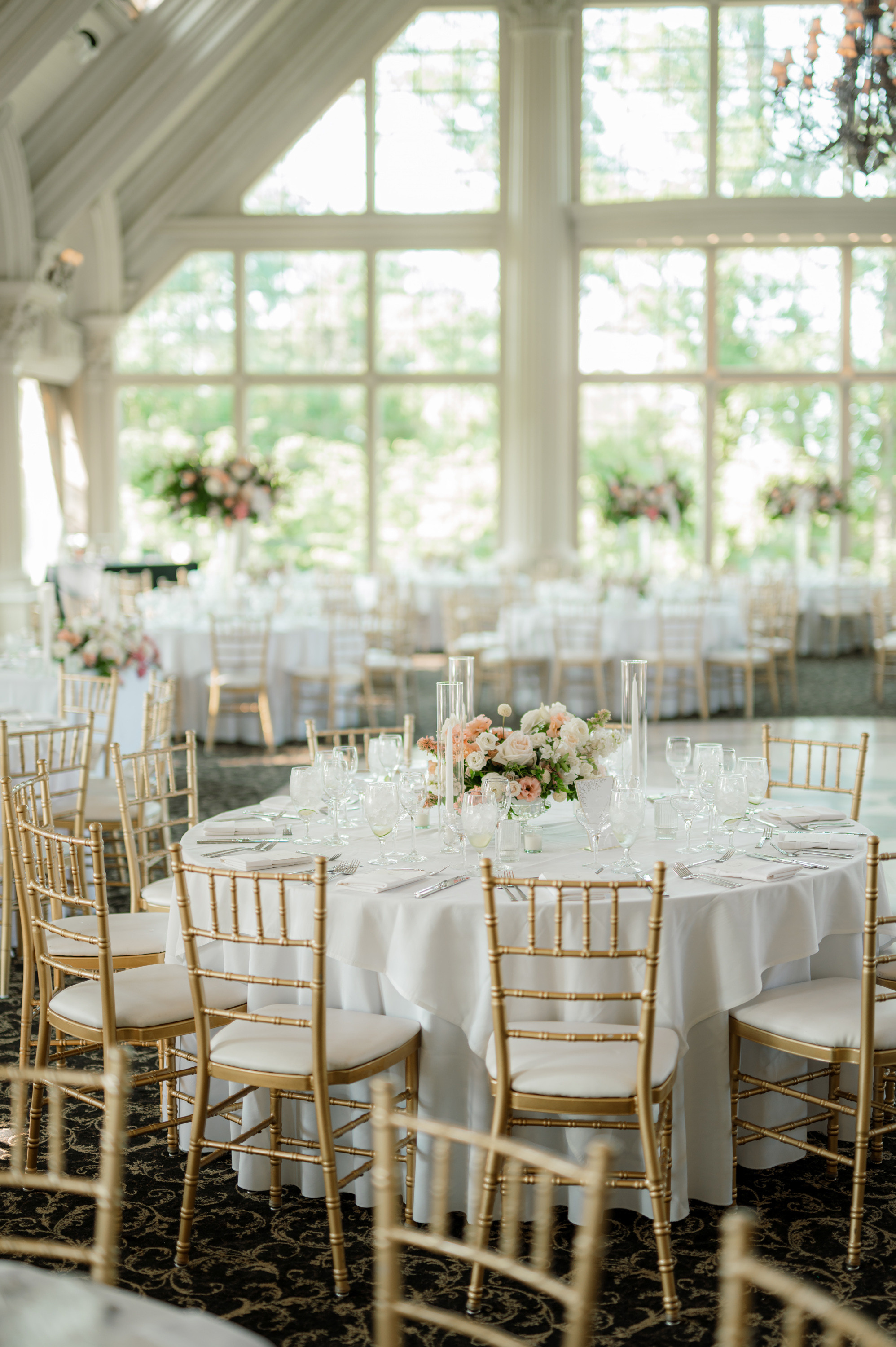 a wedding reception with white tablecloths and gold chairs