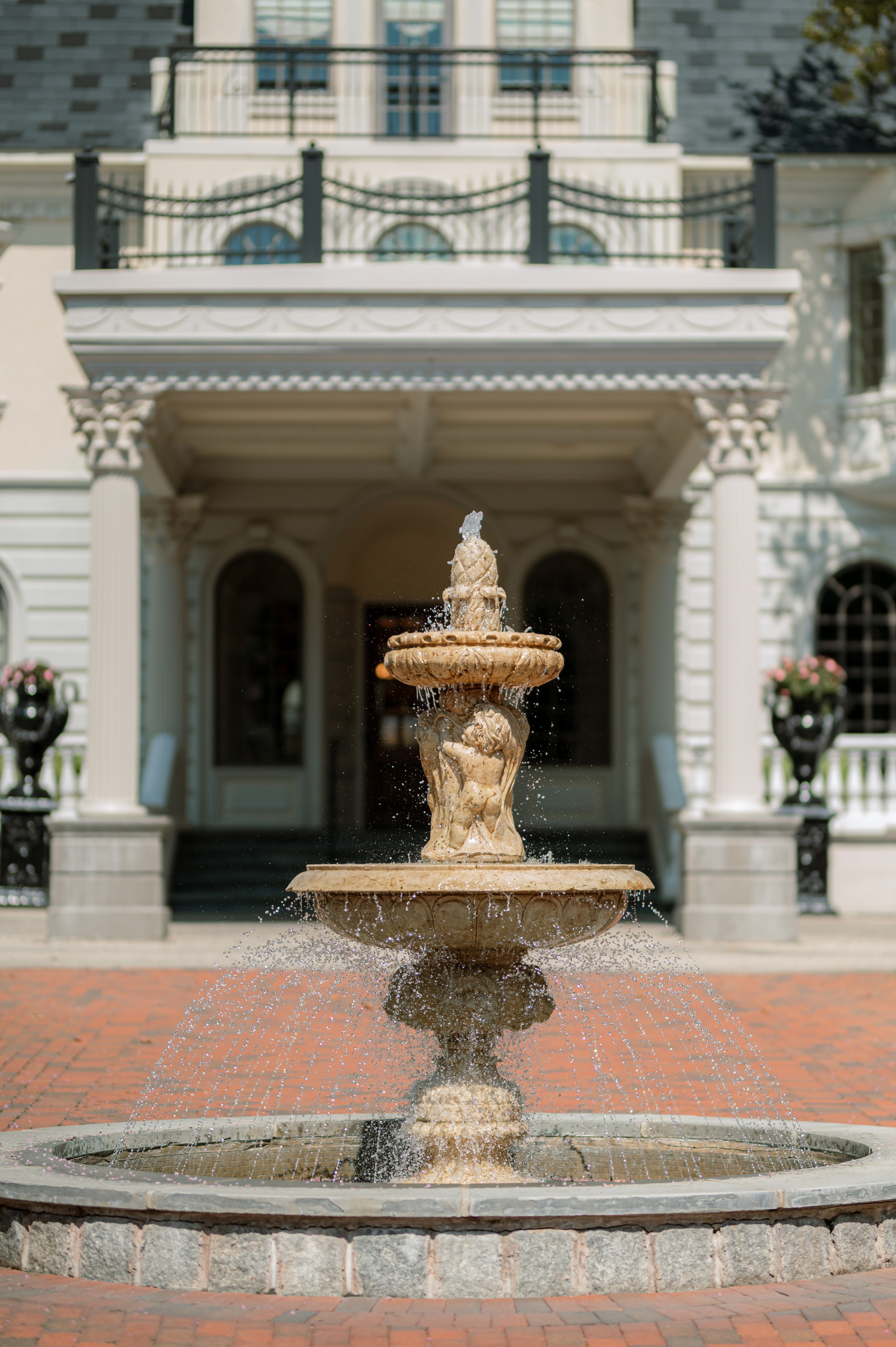a fountain in front of a large house