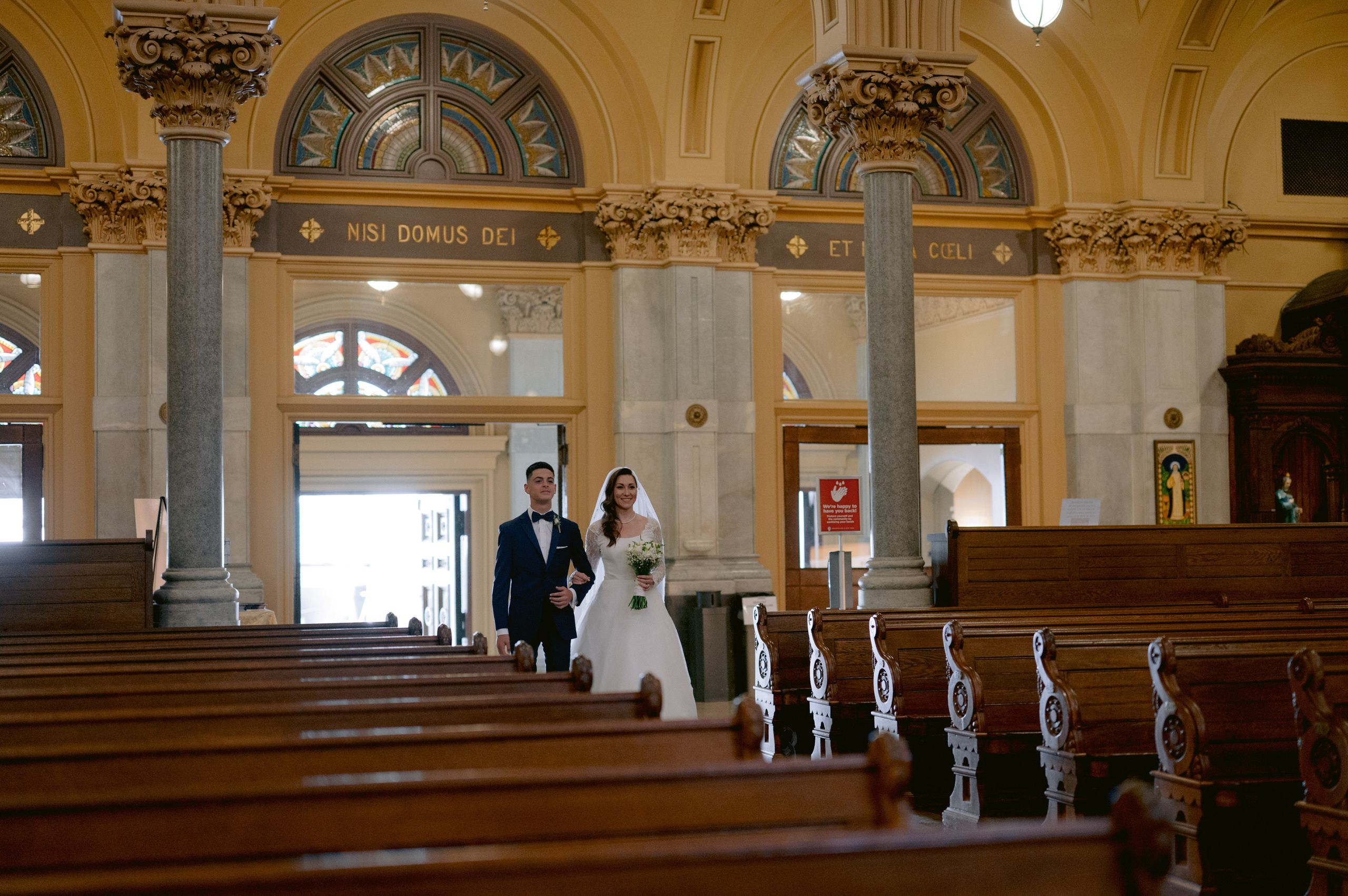 a bride and groom walking down the aisle of a church