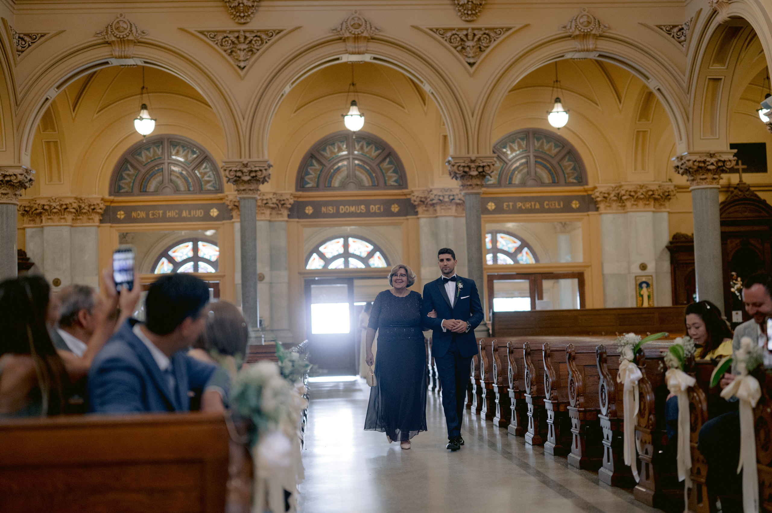 a man and woman walking down a church aisle