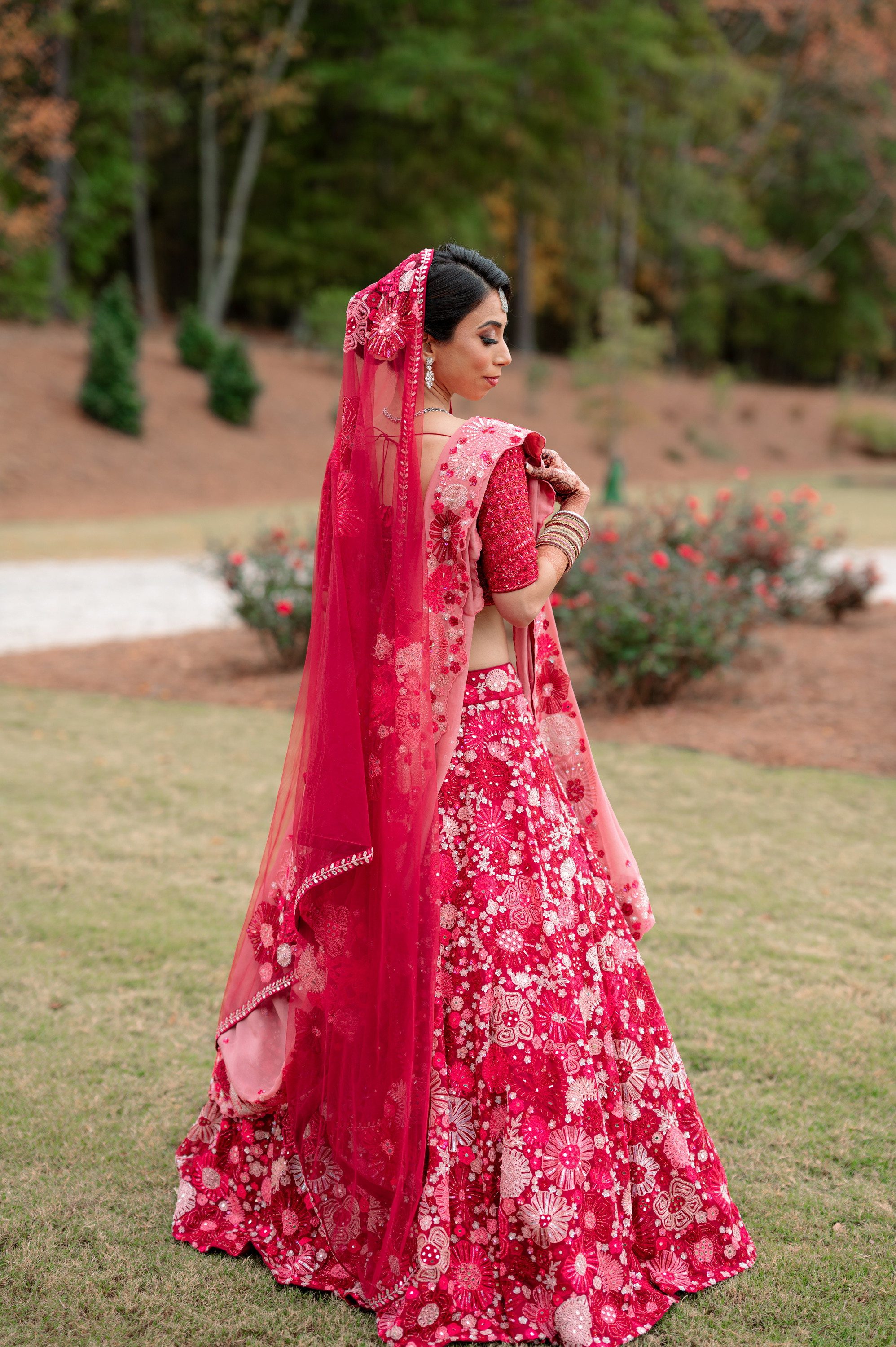 a woman in a red and pink lehen