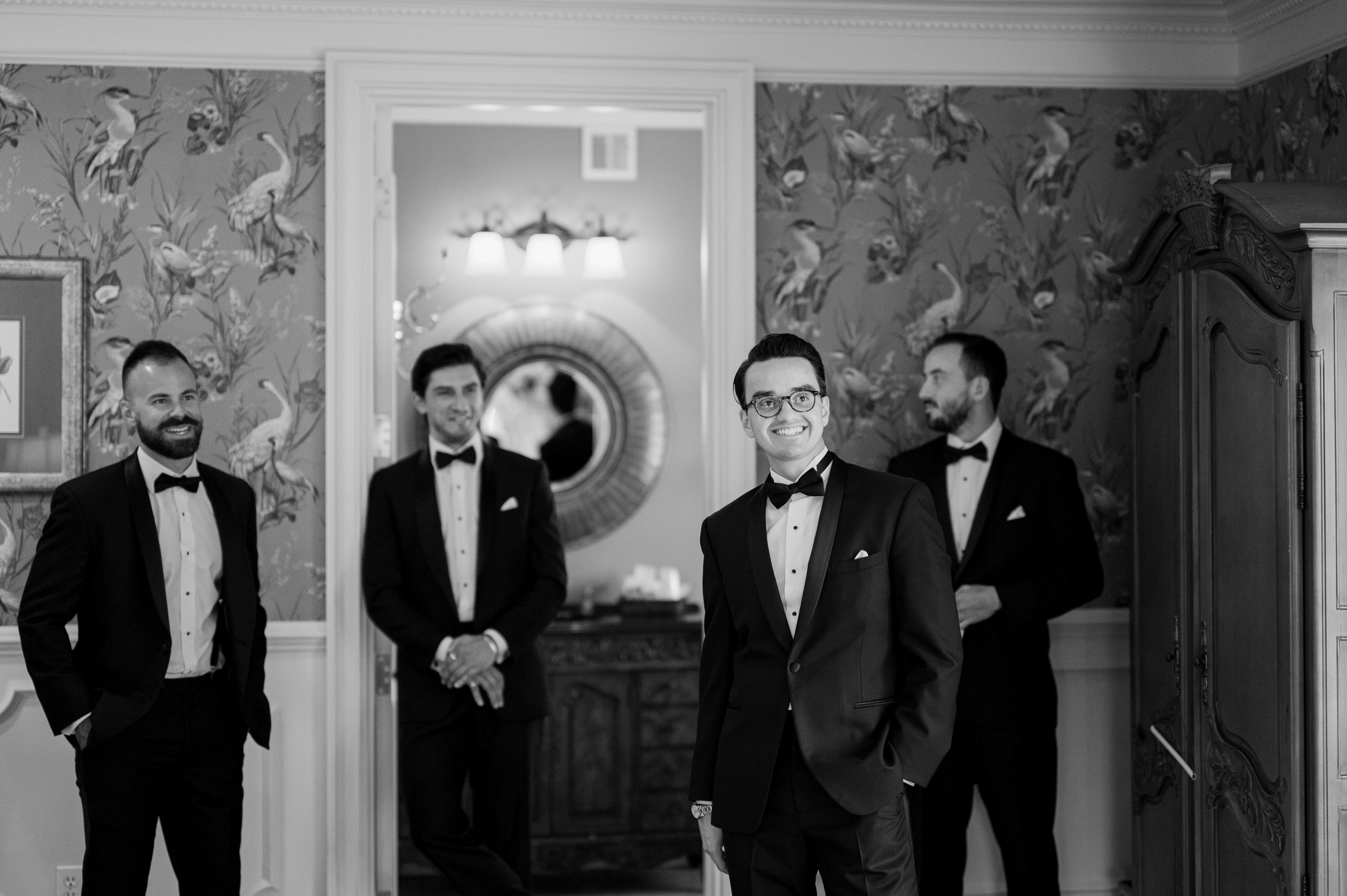 a group of men in tuxed suits standing in a room