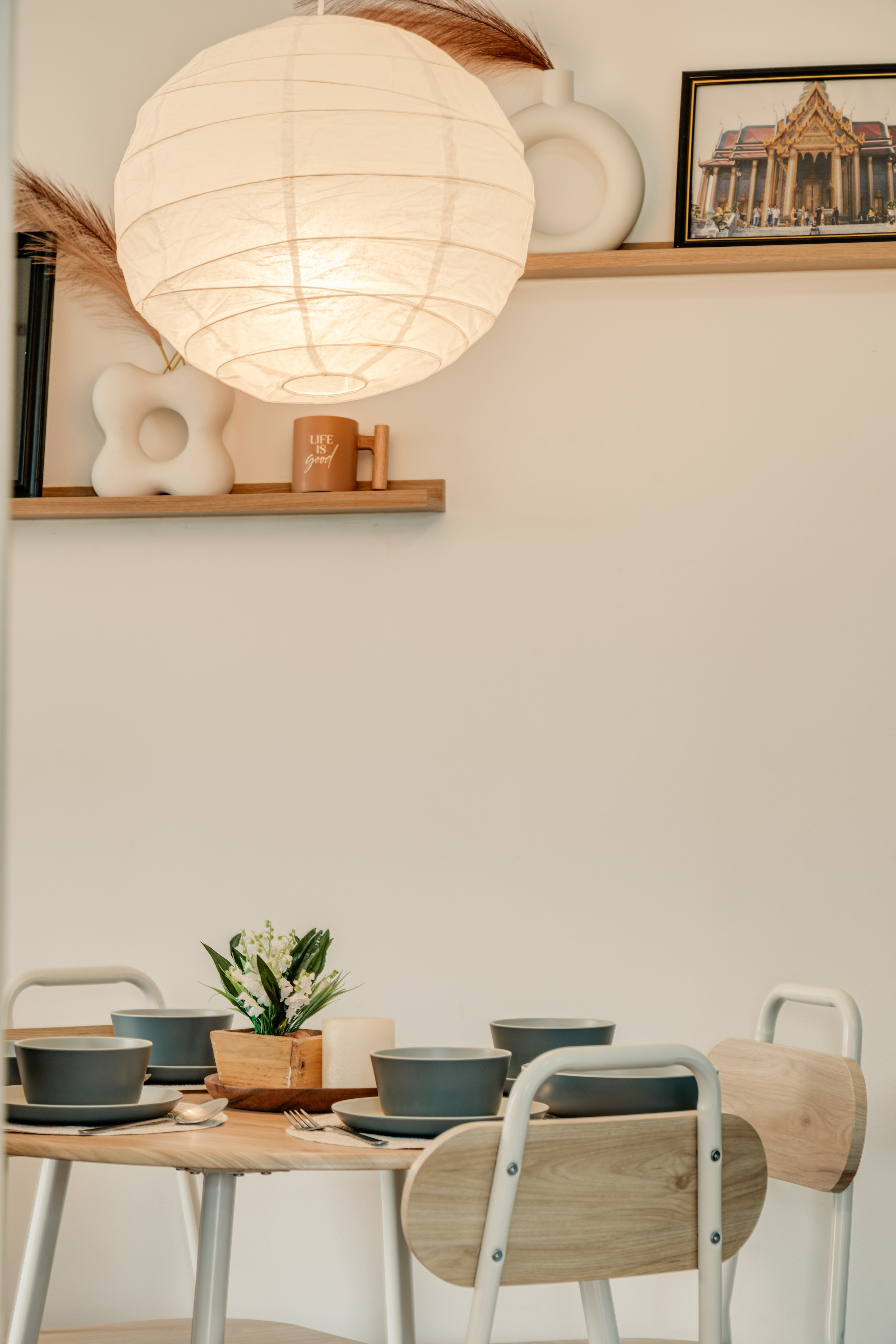 Professional interior photograph of a modern condo featuring a minimalist living room, dining area, warm wood finishes, and soft natural lighting.