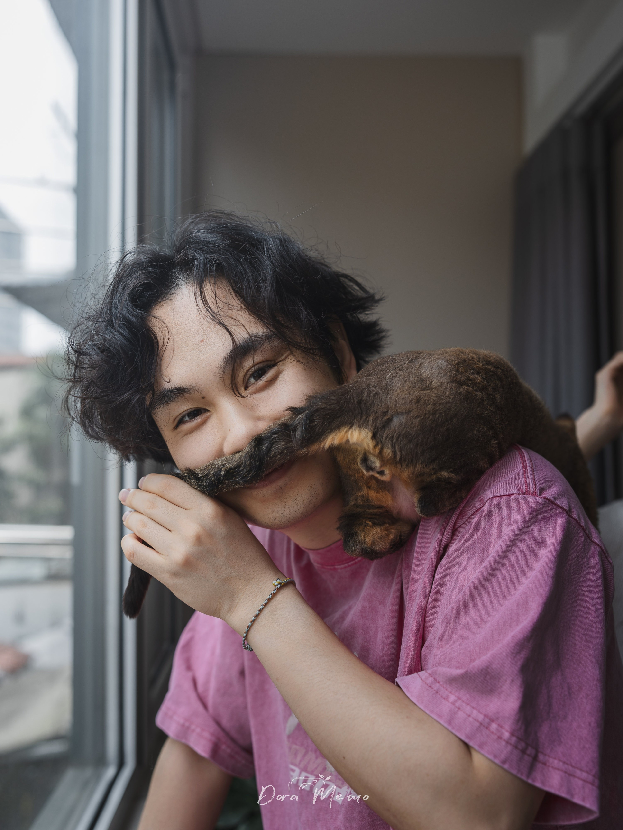  A father smiles as his cat climbs close to his face in a funny everyday pet family moment.