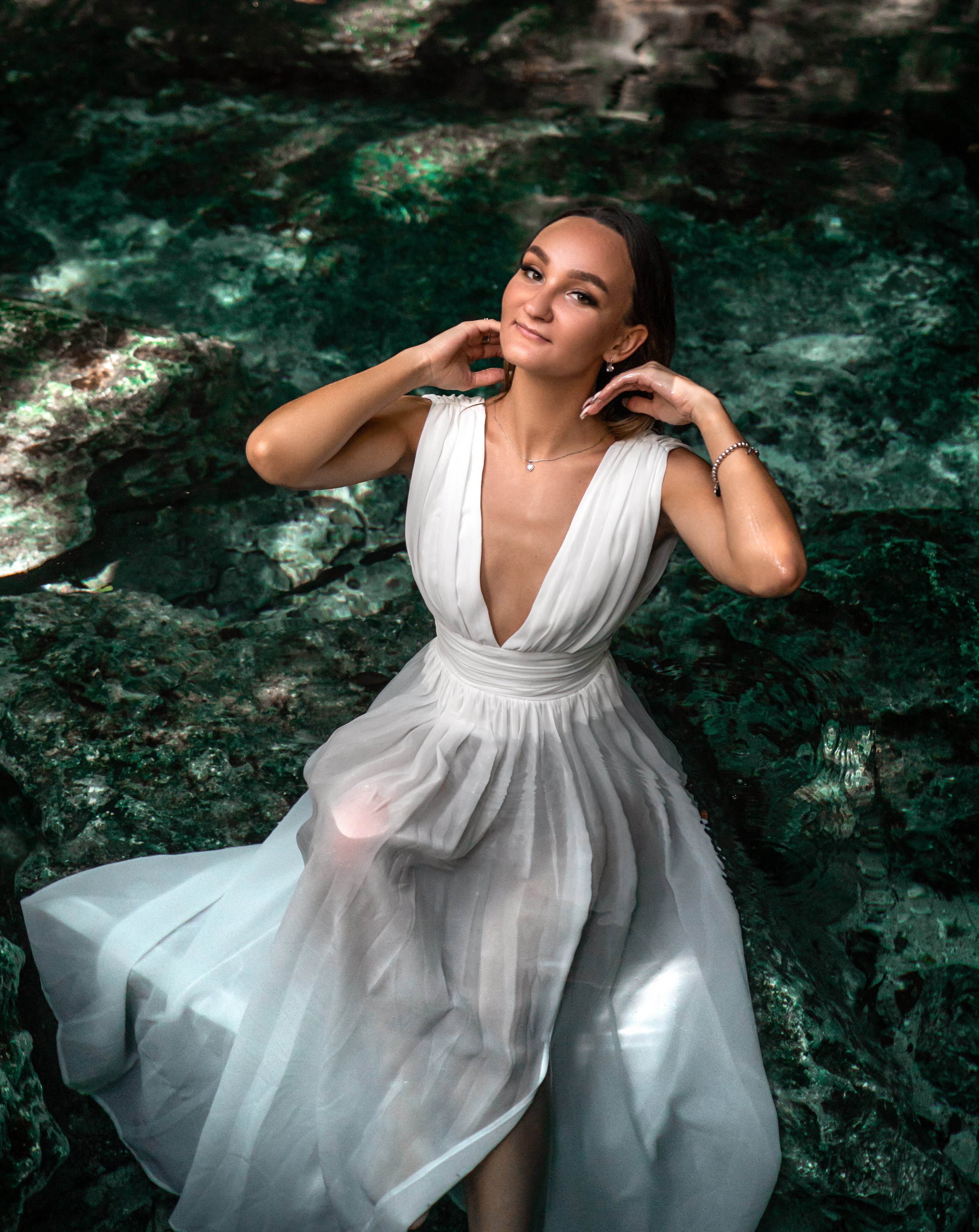 Woman in white dress reacting to surprise proposal in Tulum