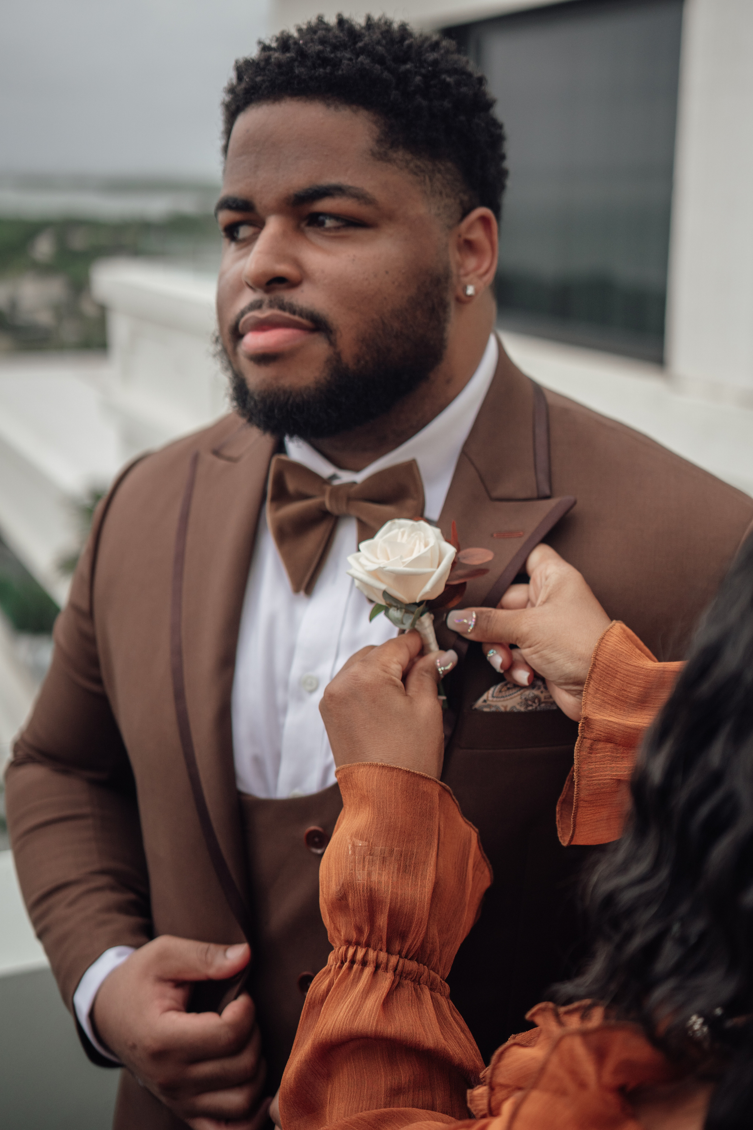 Groom fixing his jacket during wedding day prep in Cancun