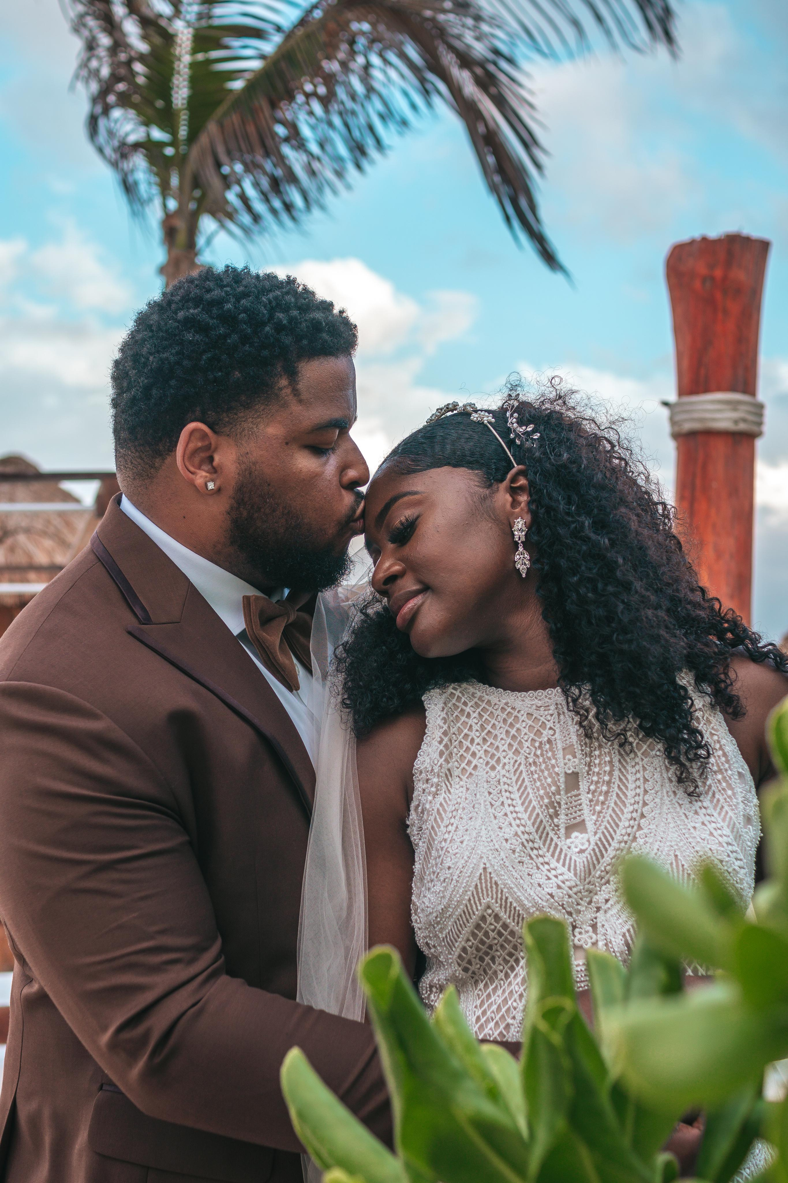 Cloudy beach wedding photo in Cancun – romantic couple kiss