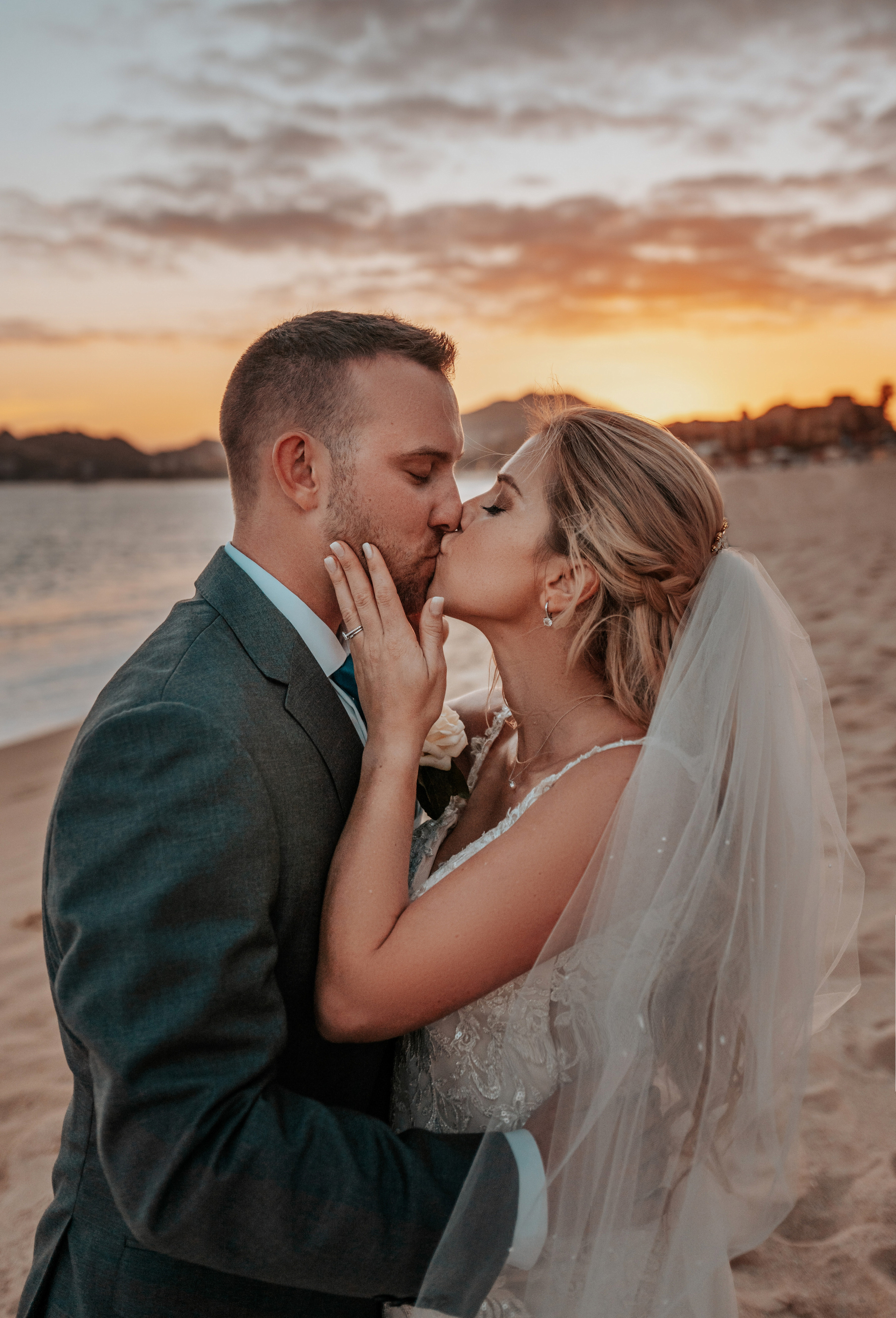 Elegant bride in lace gown on Cabo San Lucas beach during sunset