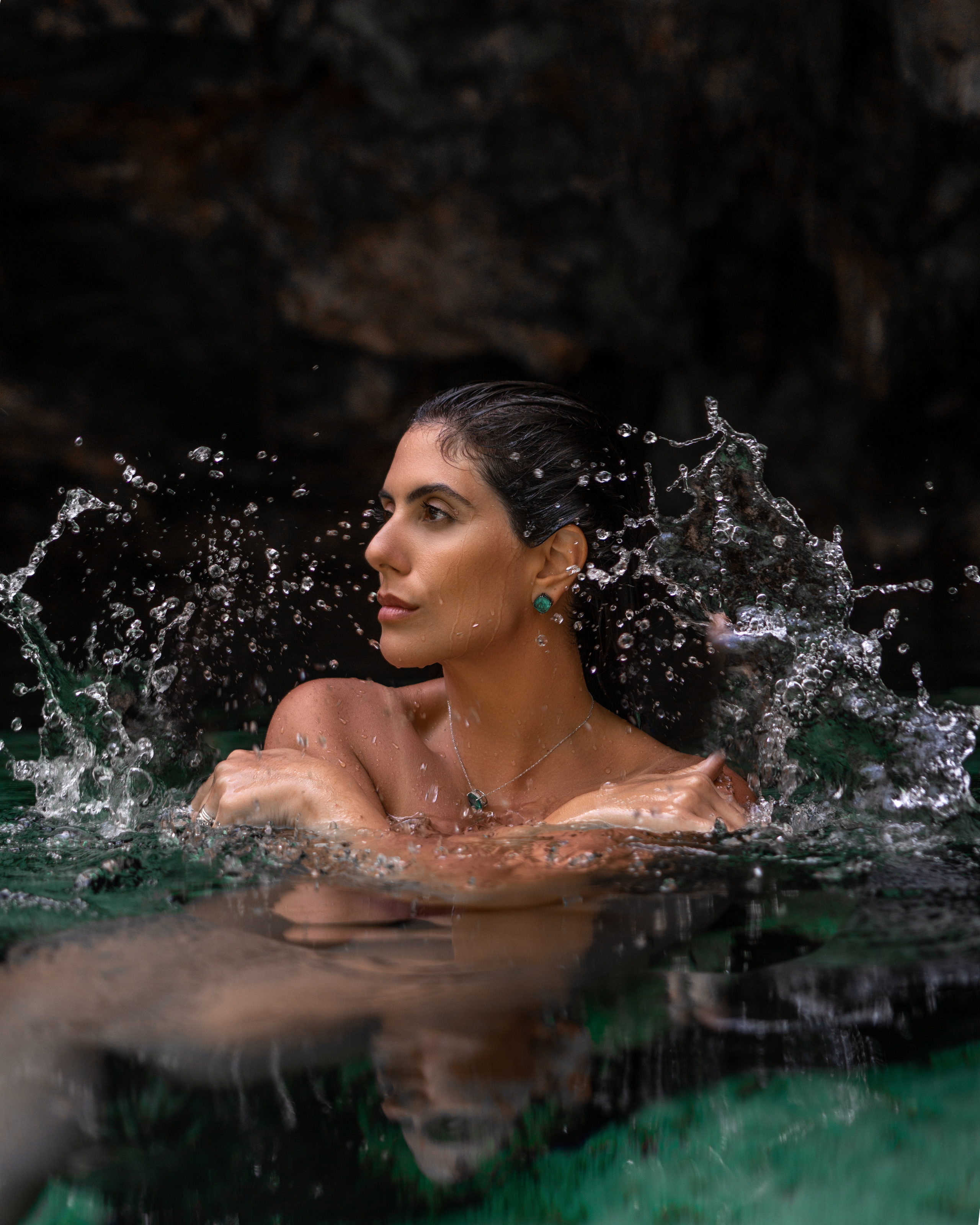 Woman posing in emerald cenote waters, Tulum