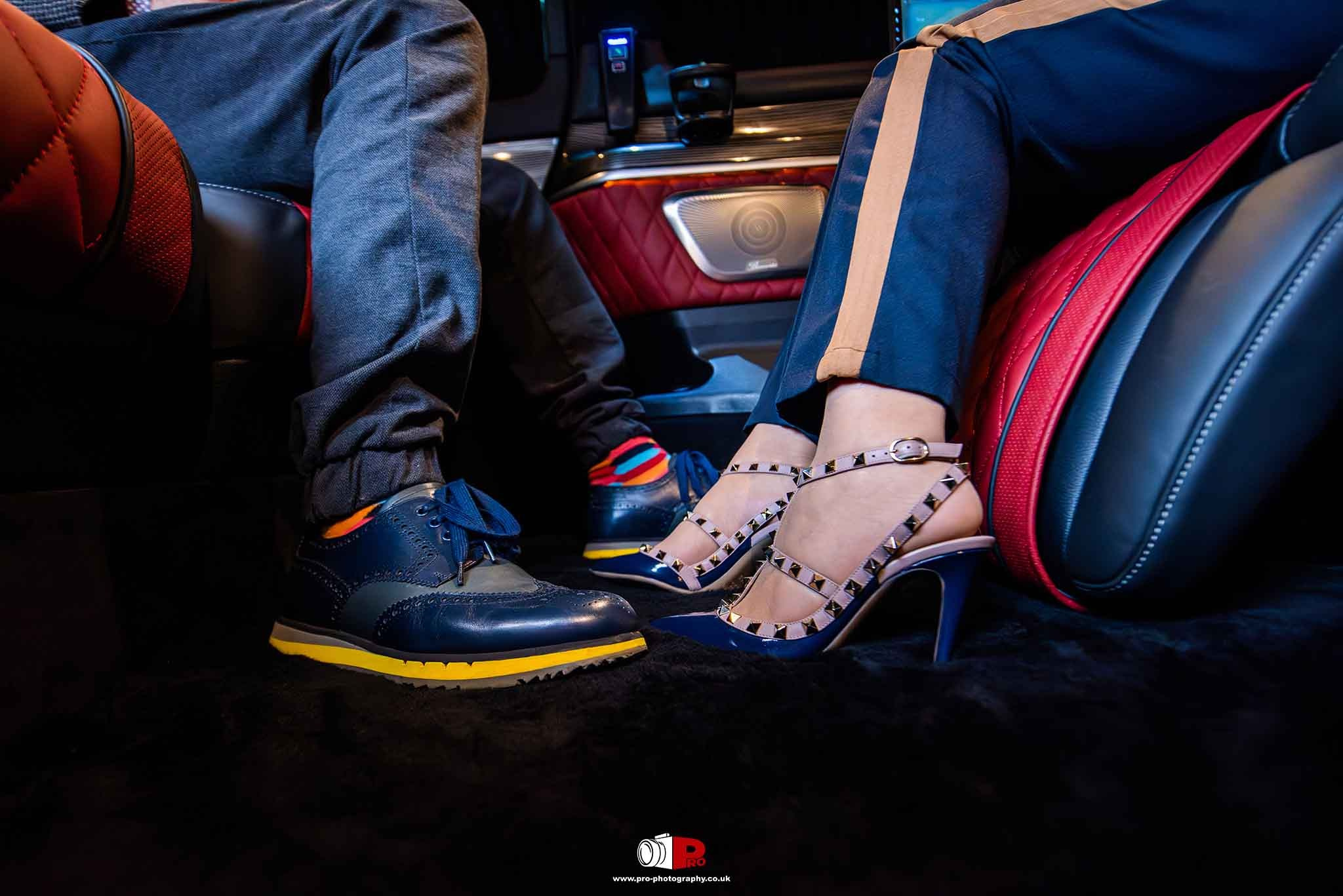  Fashionable shoes resting in a sleek and luxurious car interior with red leather seats.