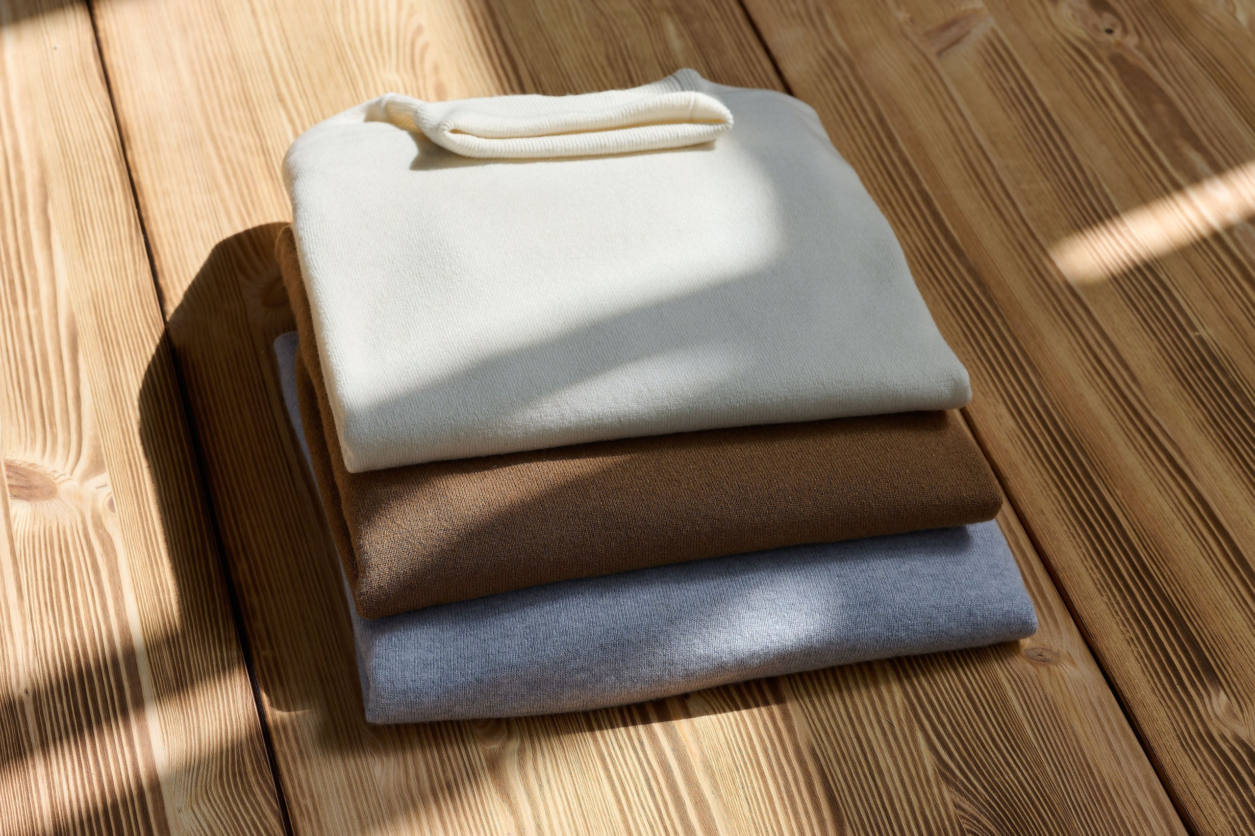 Produktfotografie Wien – Nahaufnahme eines gefalteten hellen Stoffes im Sonnenlicht.