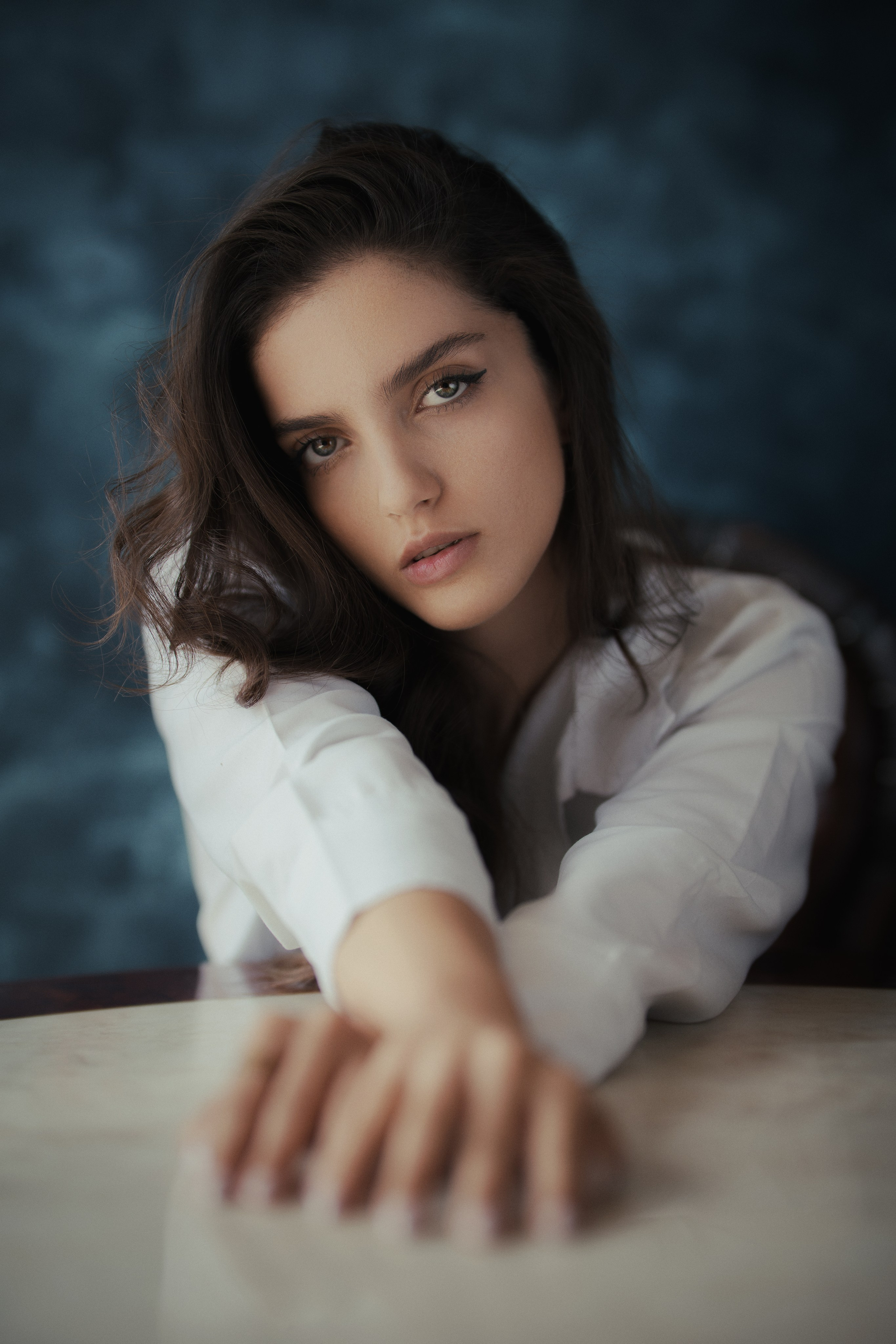 Creative female portrait photography by Mehran Hadad featuring shallow depth of field, an outstretched hand, and cinematic studio lighting.