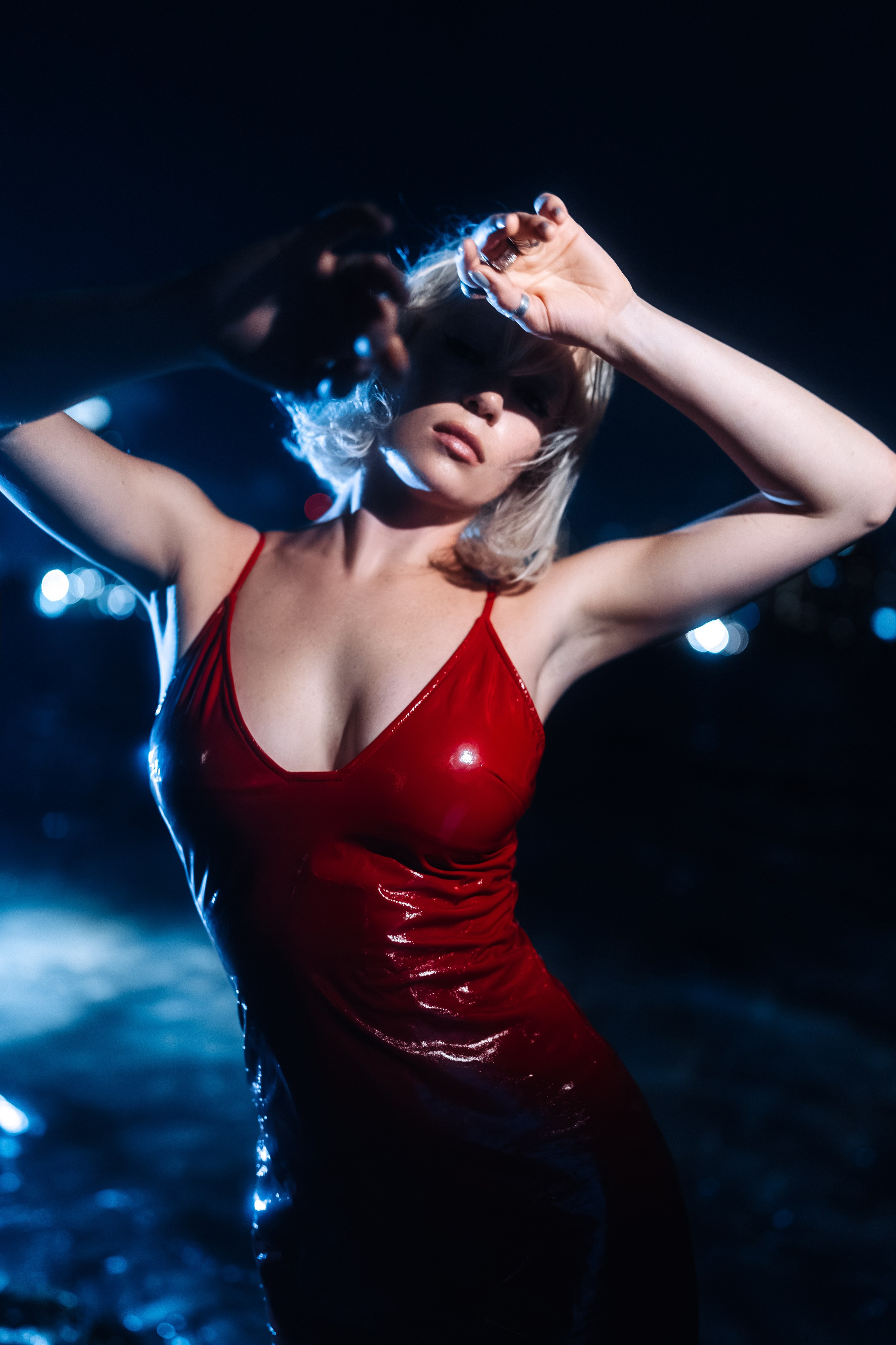 The model’s silhouette against the city skyline, highlighted by light. The frame appears premium and refined.