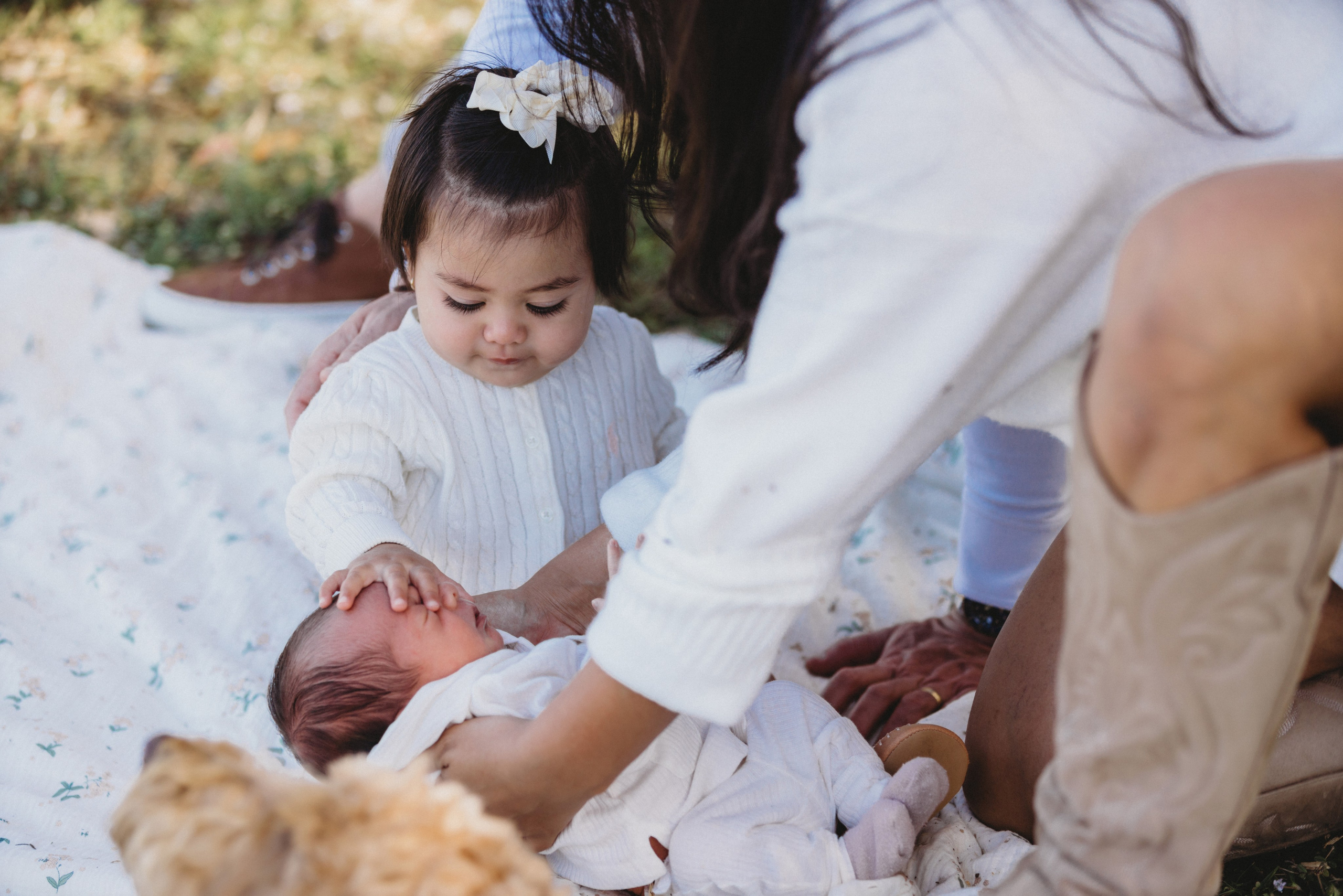Big sister touching baby's face