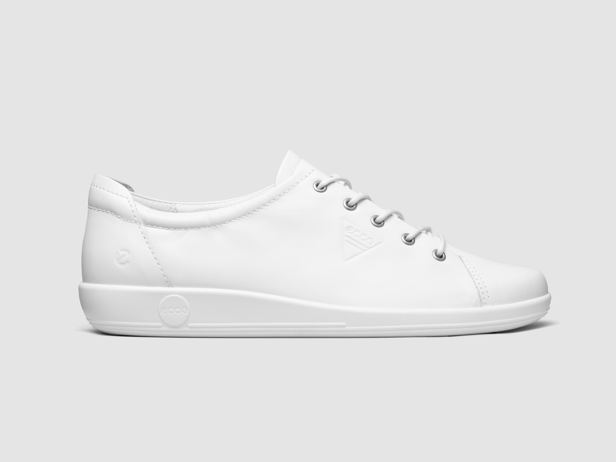 White sneakers side view white background minimal footwear photography