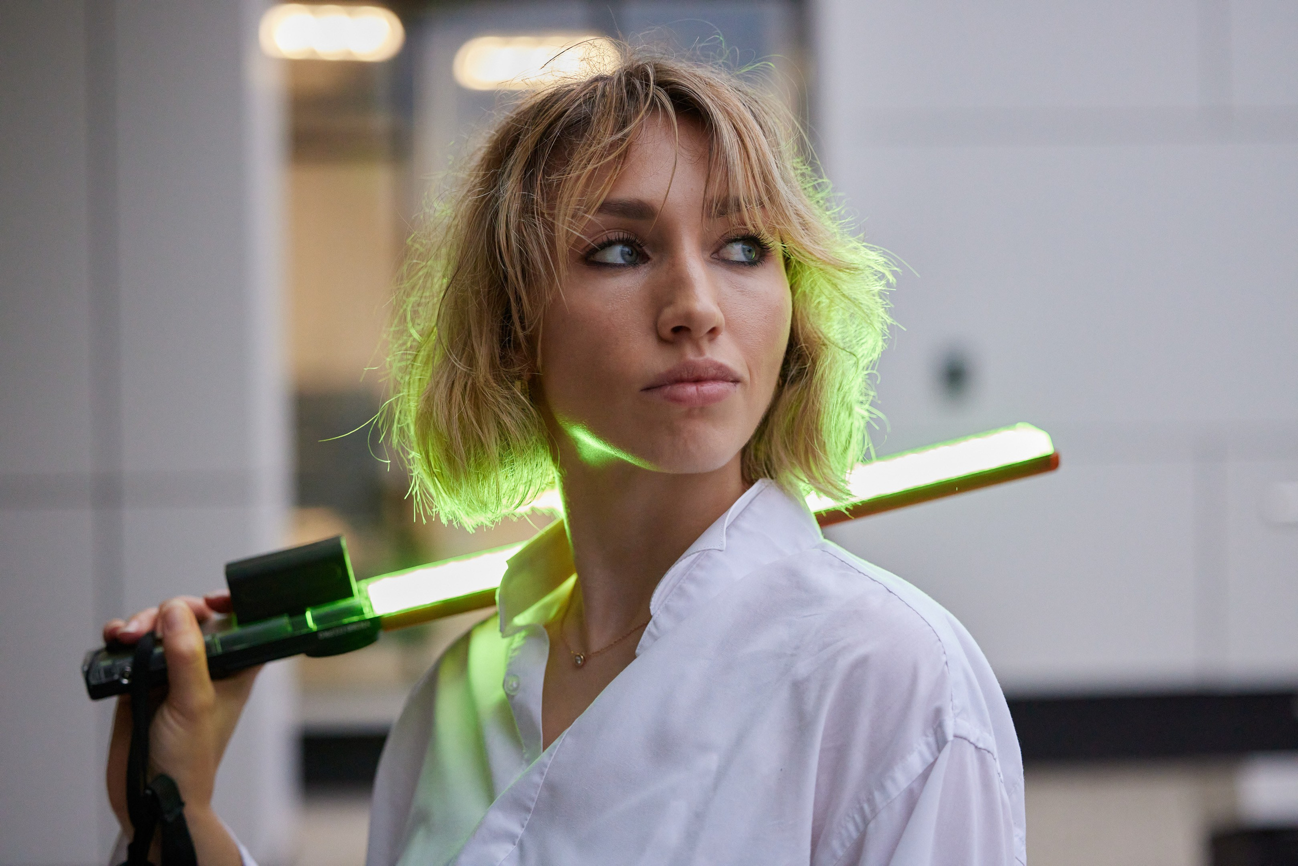 Location portrait of a young woman with colored lighting against the backdrop of a building - photographer Andrey Dunin