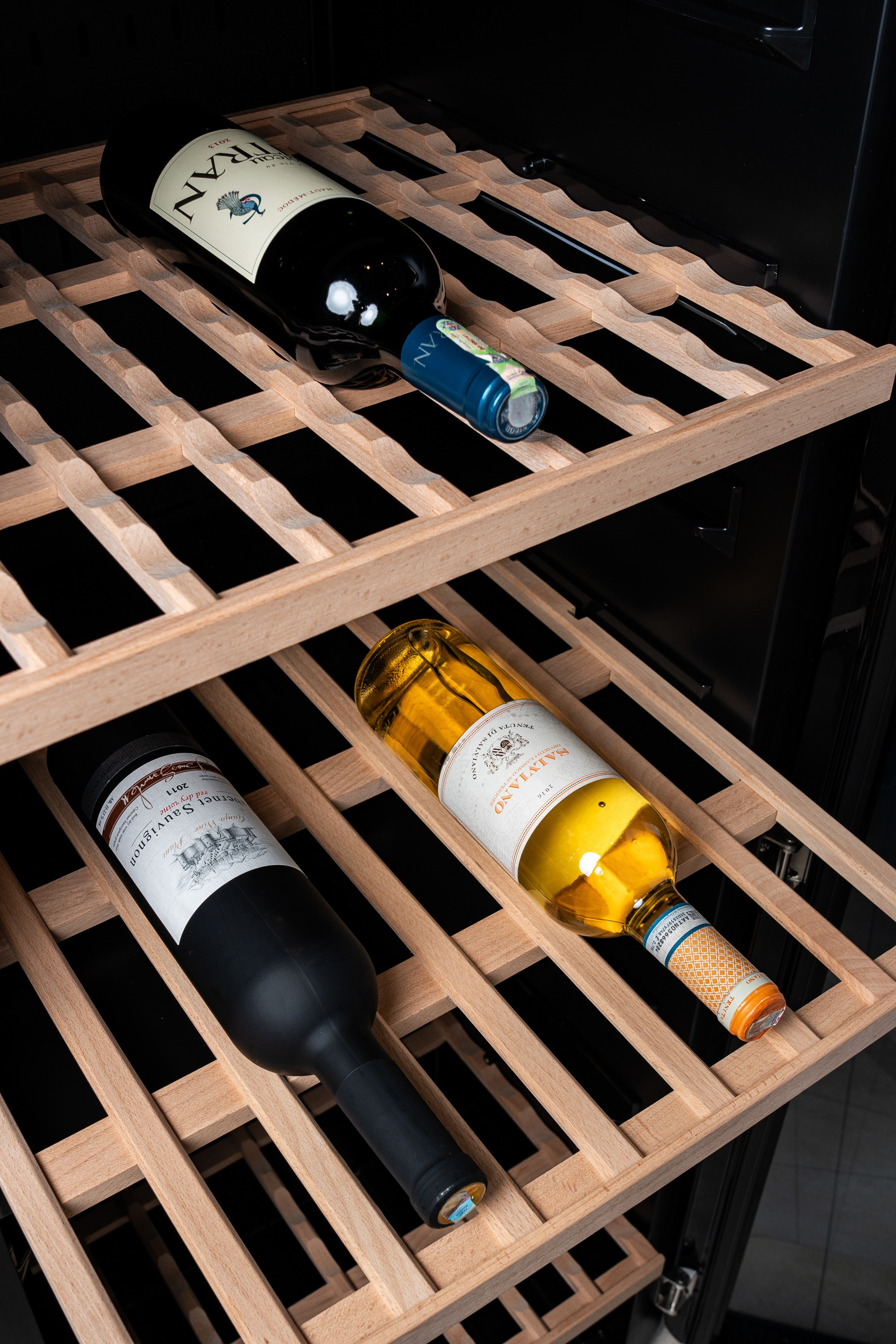 Taxta rəflərdə qırmızı və ağ şərab butulkaları — premium şərab kolleksiyası və saxlanma.